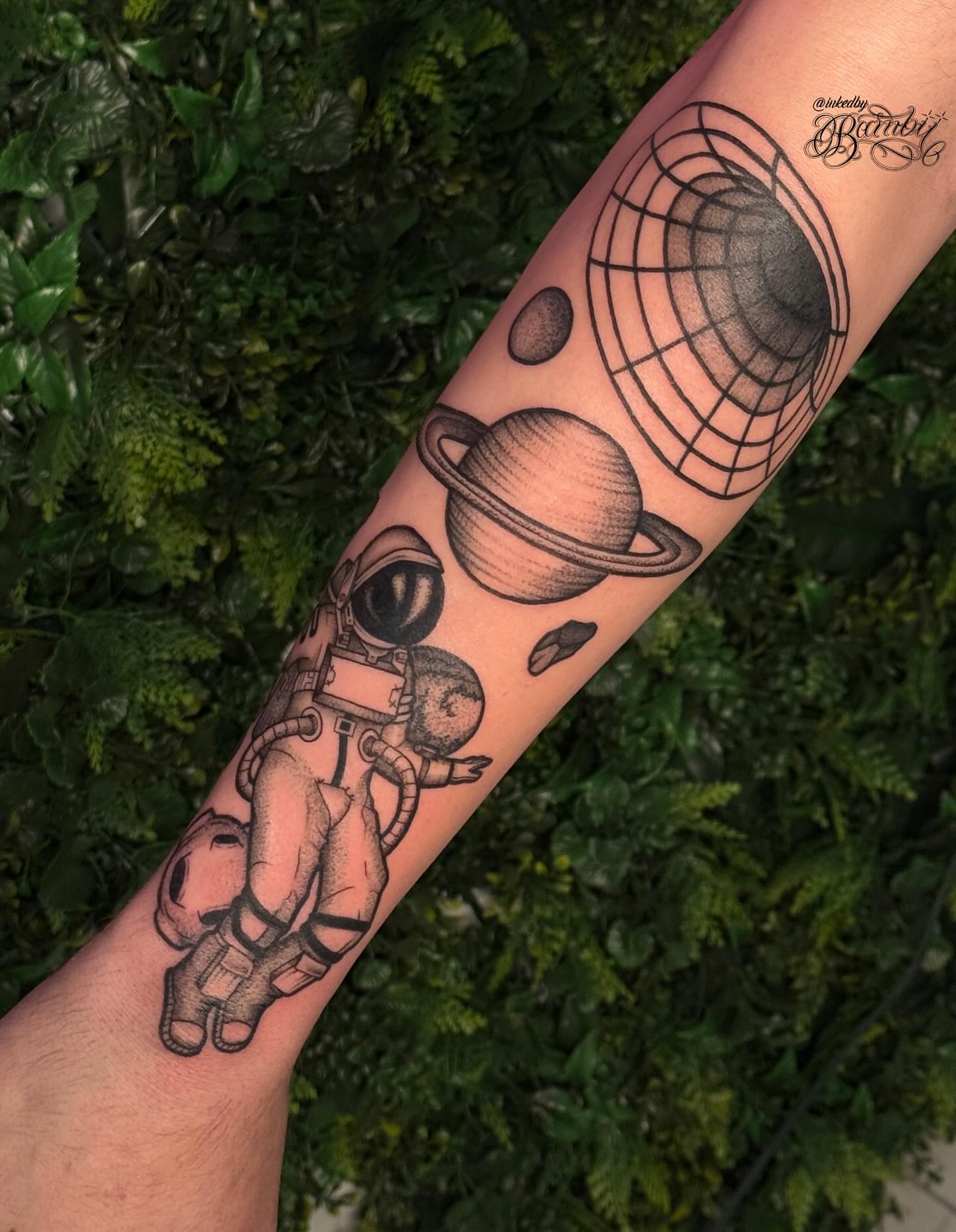 Astronaut and planets realism tattoo on the forearm by Ember