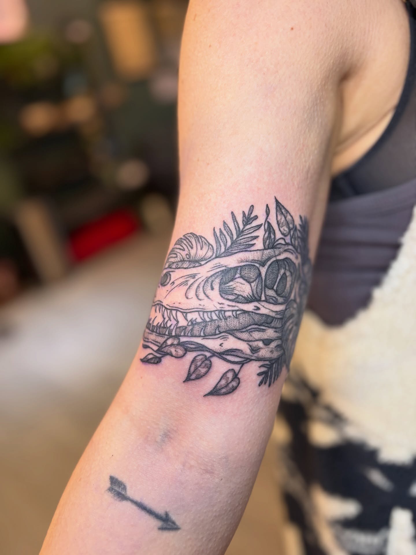 Skull with leaves black and grey tattoo on the forearm by Meg Ingersoll