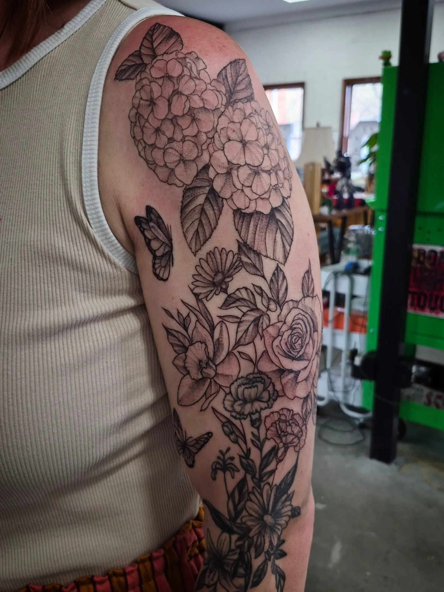 Floral bouquet black and grey tattoo on the upper arm by Lydia Kiley
