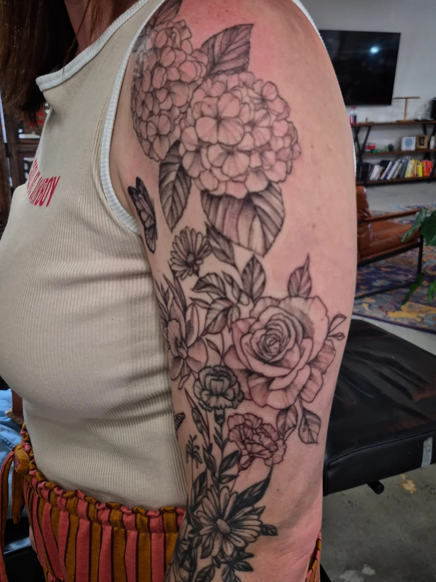 Floral bouquet black and grey tattoo on the upper arm by Lydia Kiley