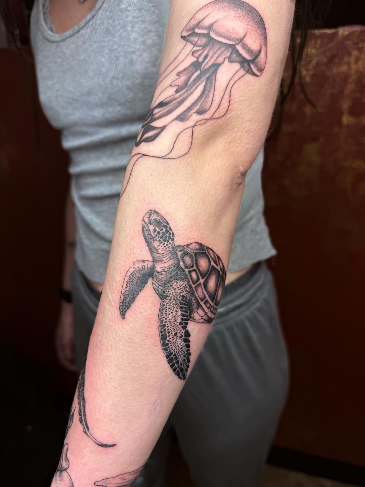 Turtle and jellyfish realism tattoo on the forearm by Imani