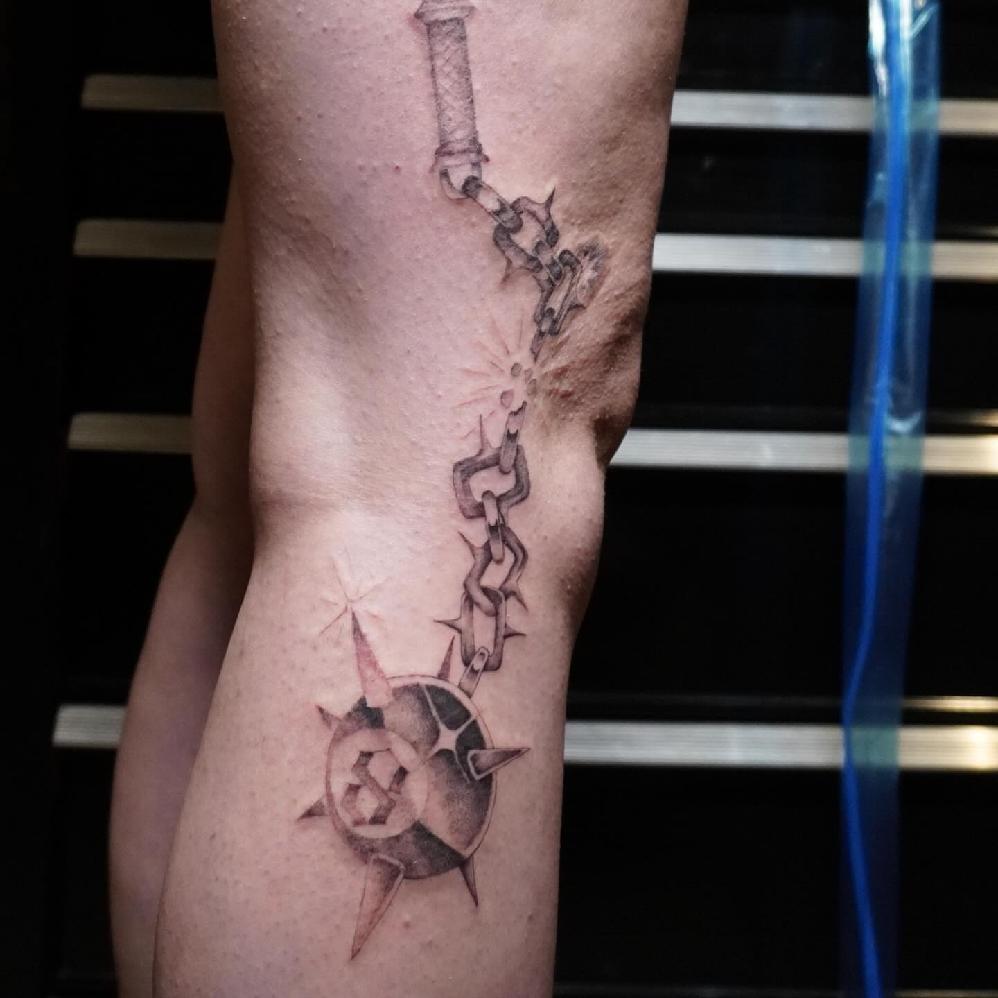 Chain and compass black and grey tattoo on the forearm by San Diego tattoo artist