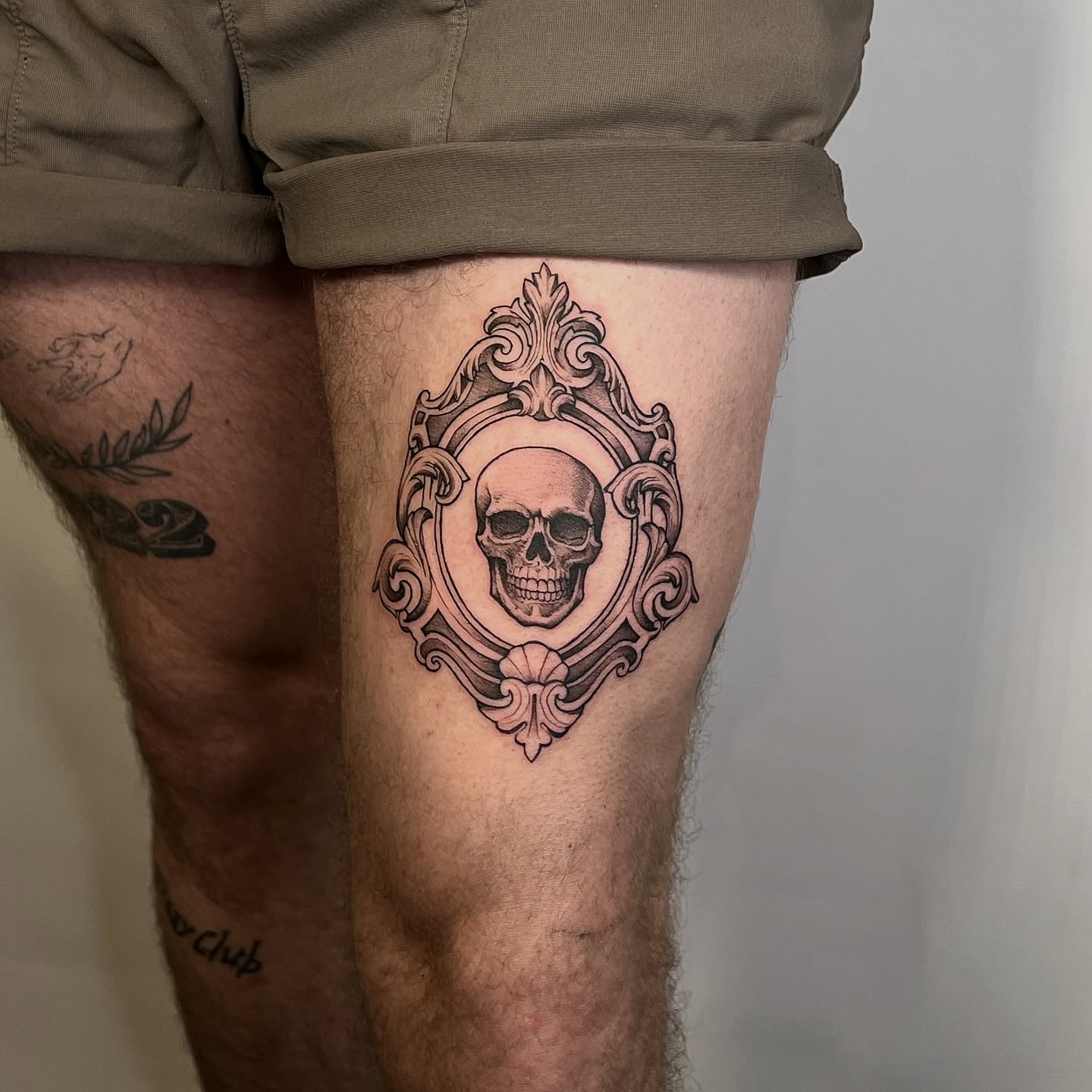 Skull in ornate frame realism tattoo on the thigh by ⚒dptattoos ⚒, East Williamsburg, Brooklyn