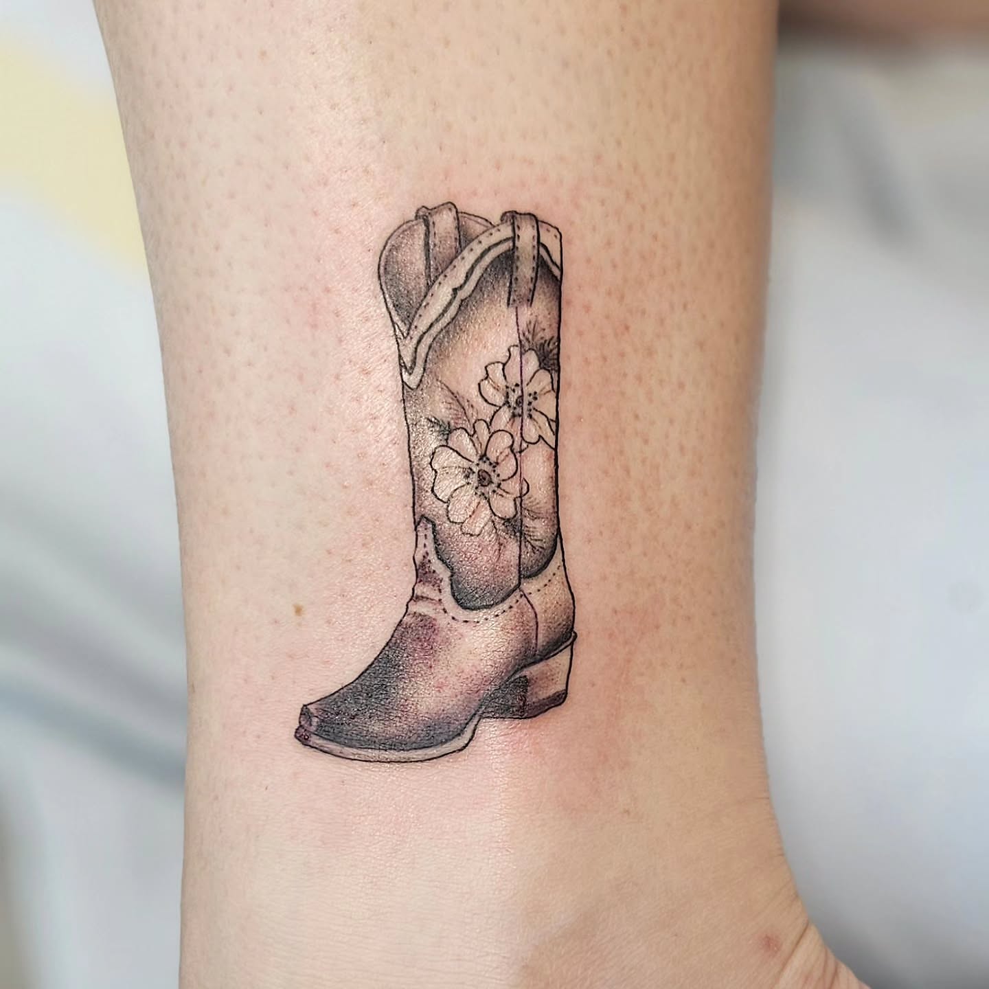 Cowboy boot black and grey tattoo on the forearm by Jordanna Pearl