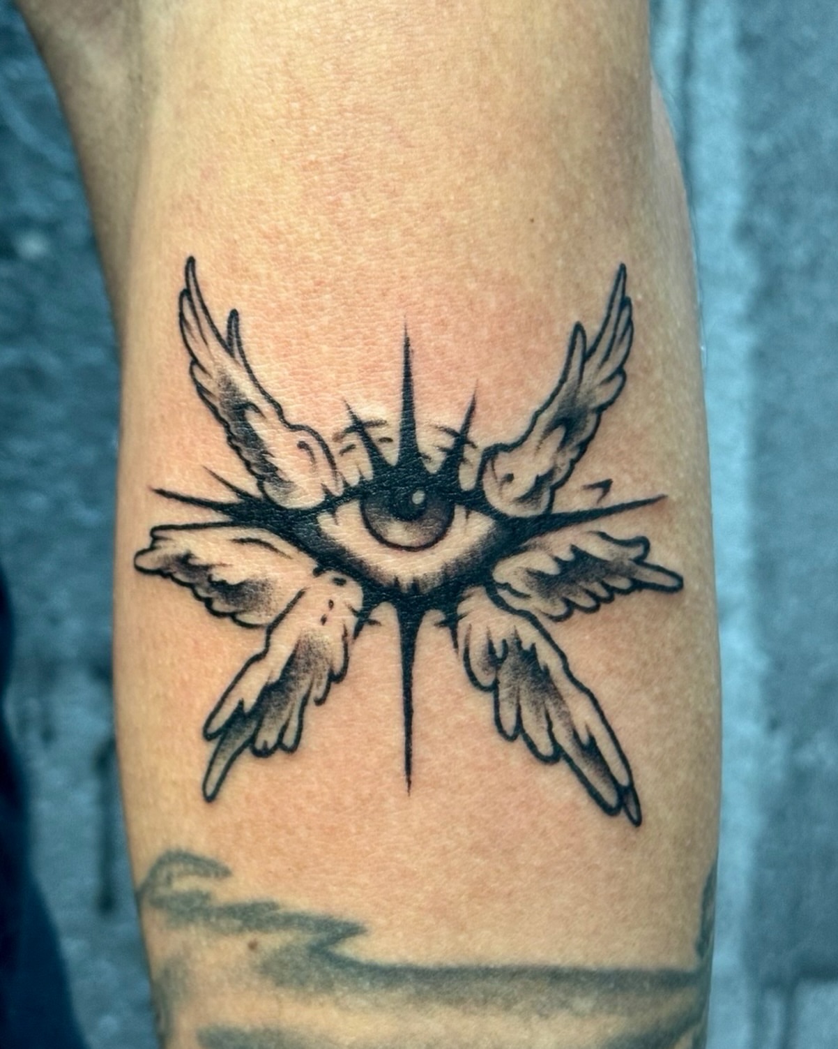 Eye with wings black and grey tattoo on the forearm by David