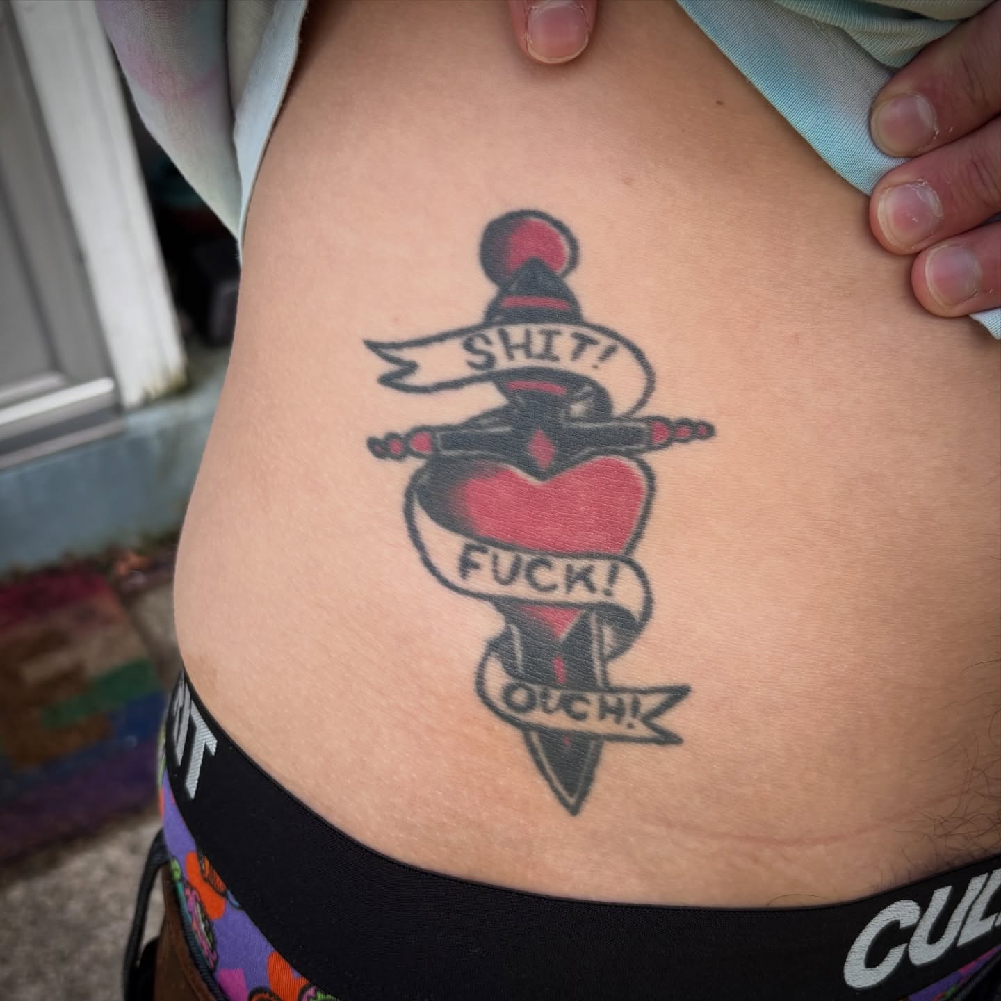 Heart with knife American traditional tattoo on the torso by Malachi