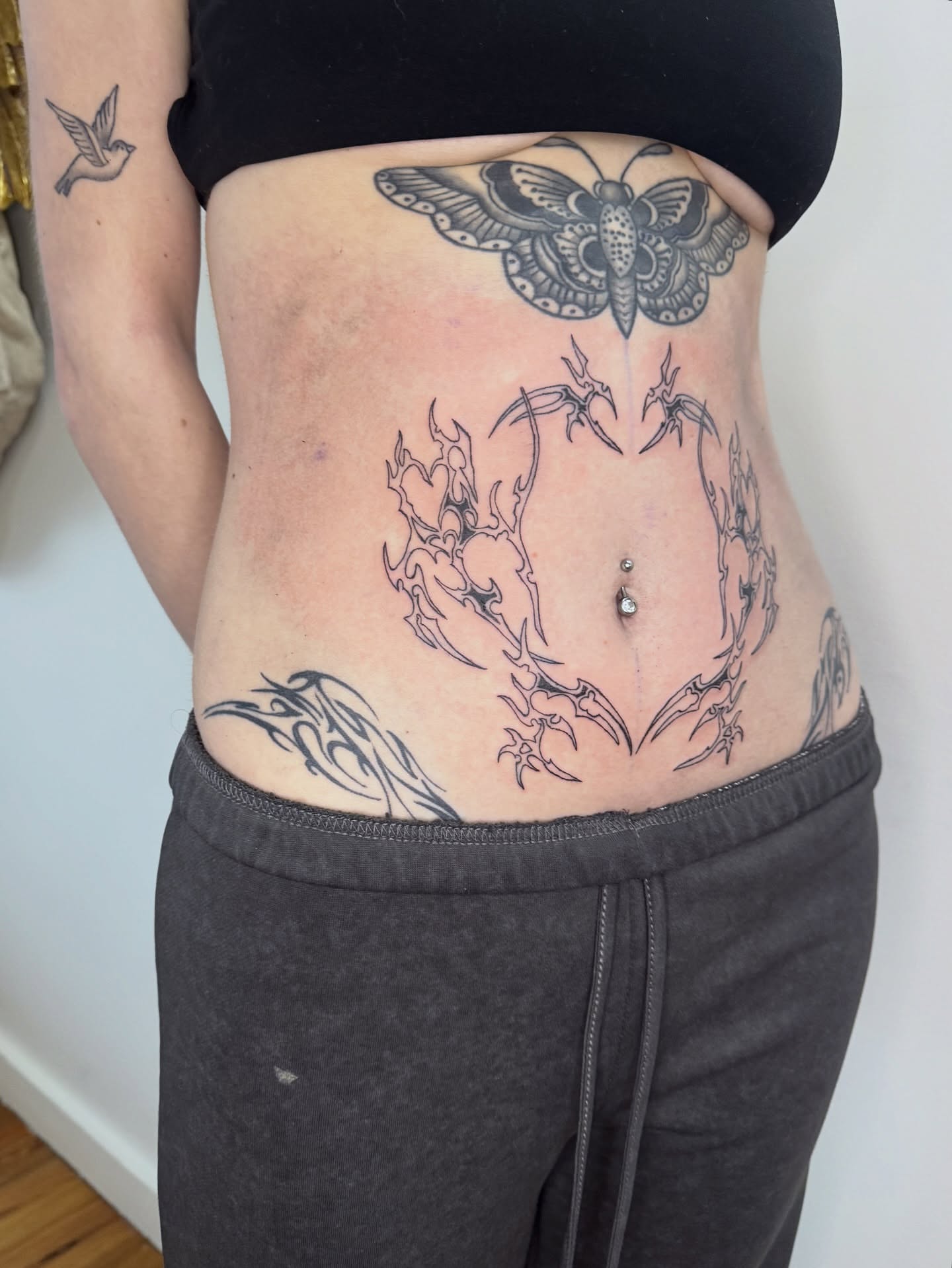 Moth and flames tribal tattoo on the torso by dev