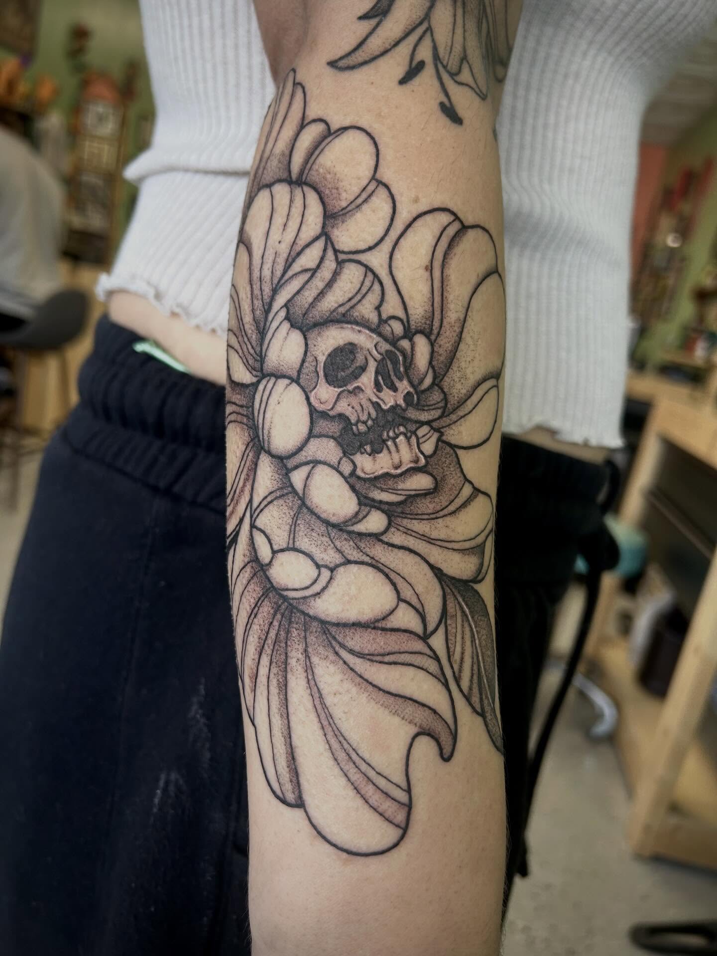 Skull and flowers dotwork tattoo on the forearm by Bria🩸