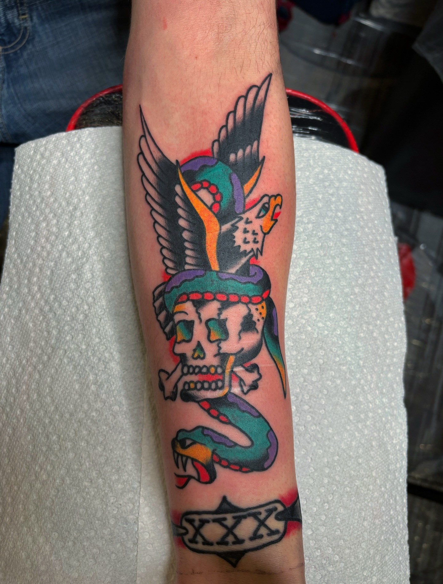 Skull with snake American traditional tattoo on the forearm by Cooper Reichwein