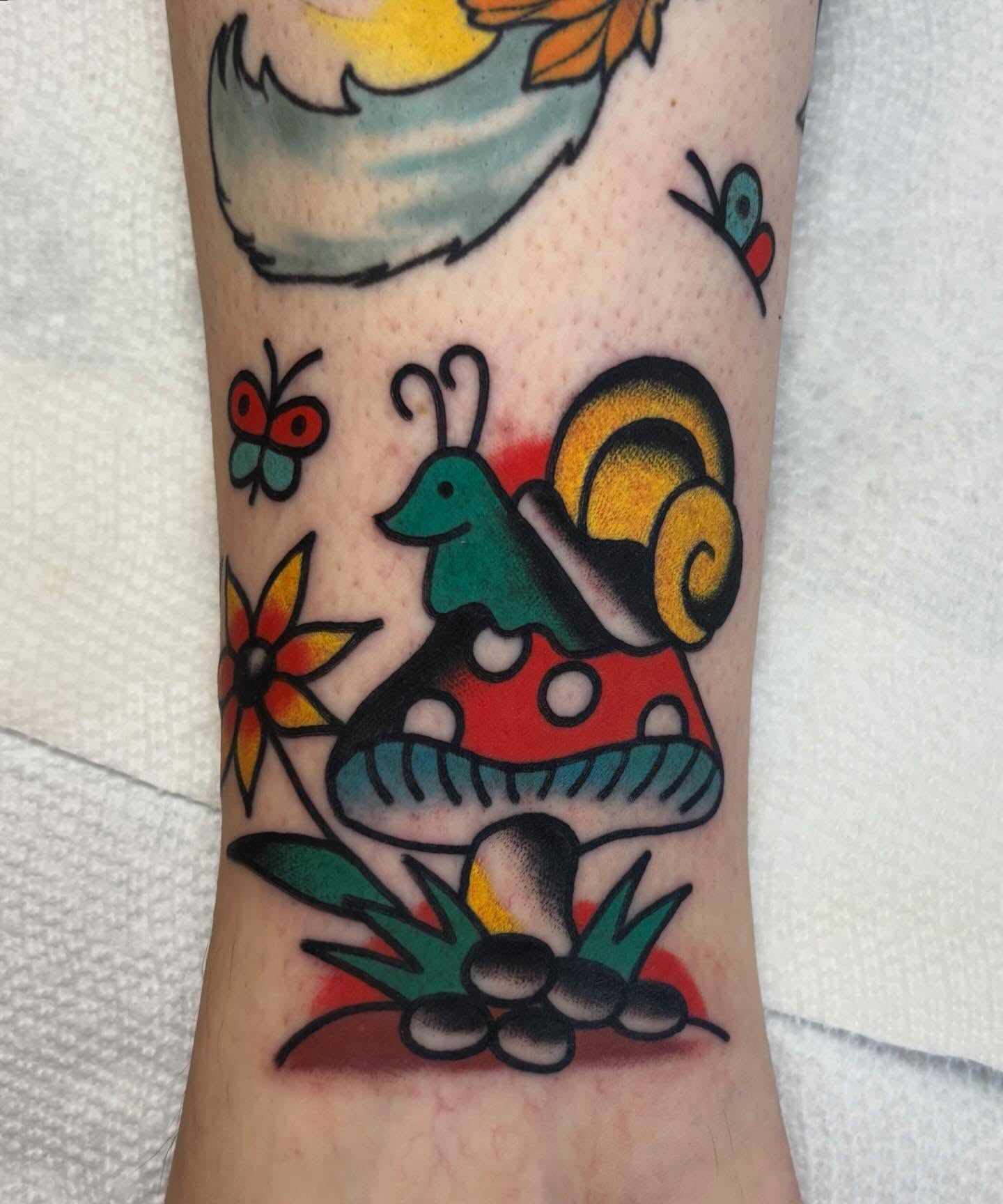 Snail and mushroom American traditional tattoo on the forearm by Traditional Tattooing