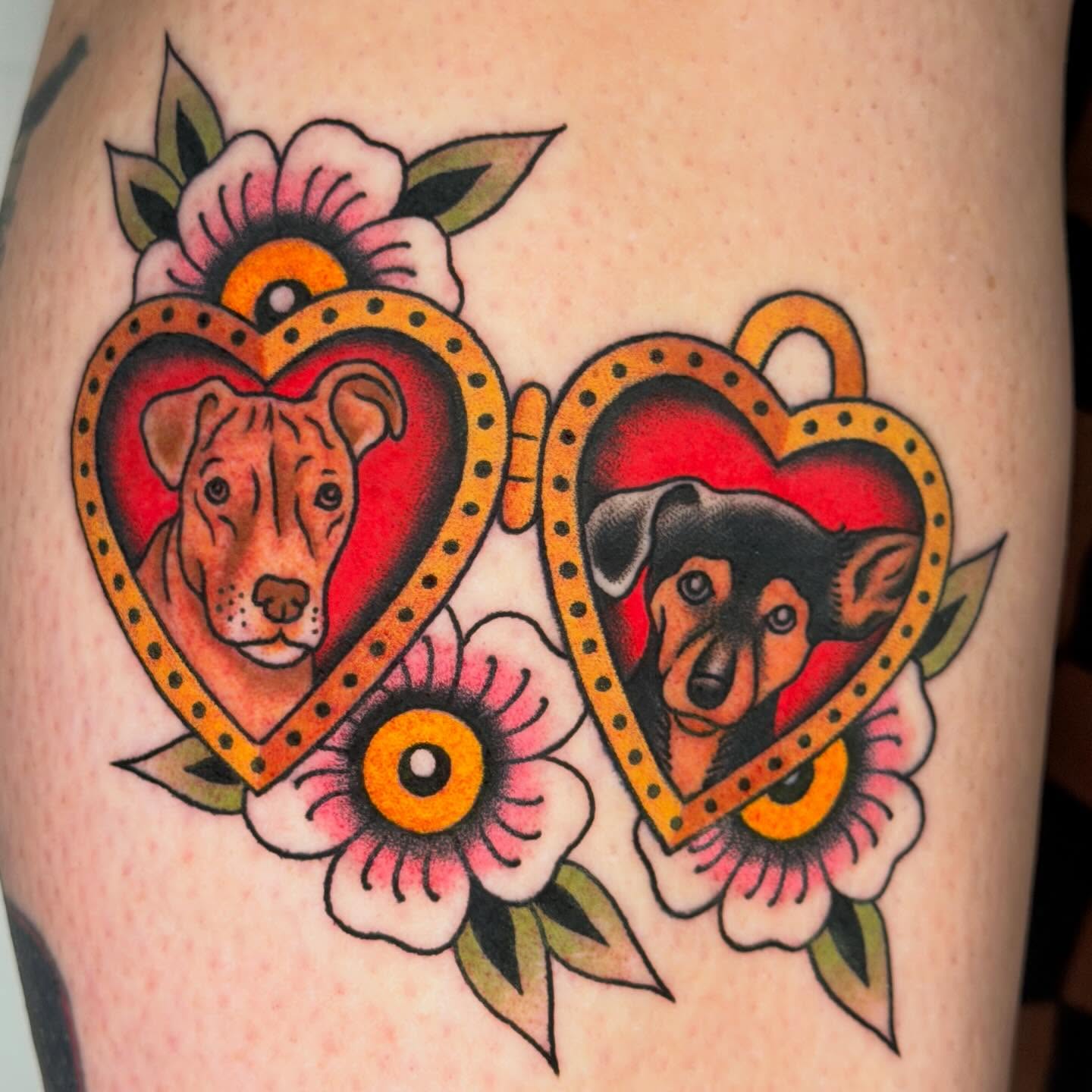Dogs in hearts American traditional tattoo on the thigh by Michael Barnhill Tattooer, Charlotte, North Carolina