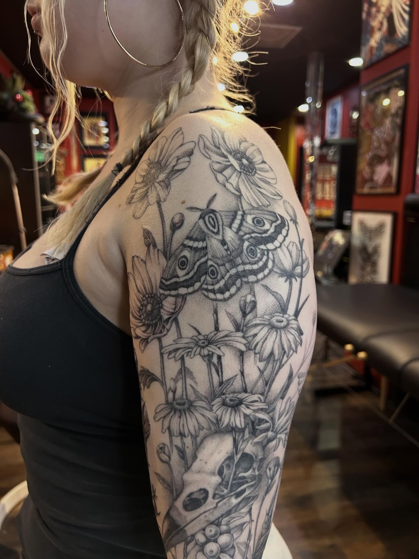 Butterfly and flowers realism tattoo on the upper arm by Tako, Seattle, Washington