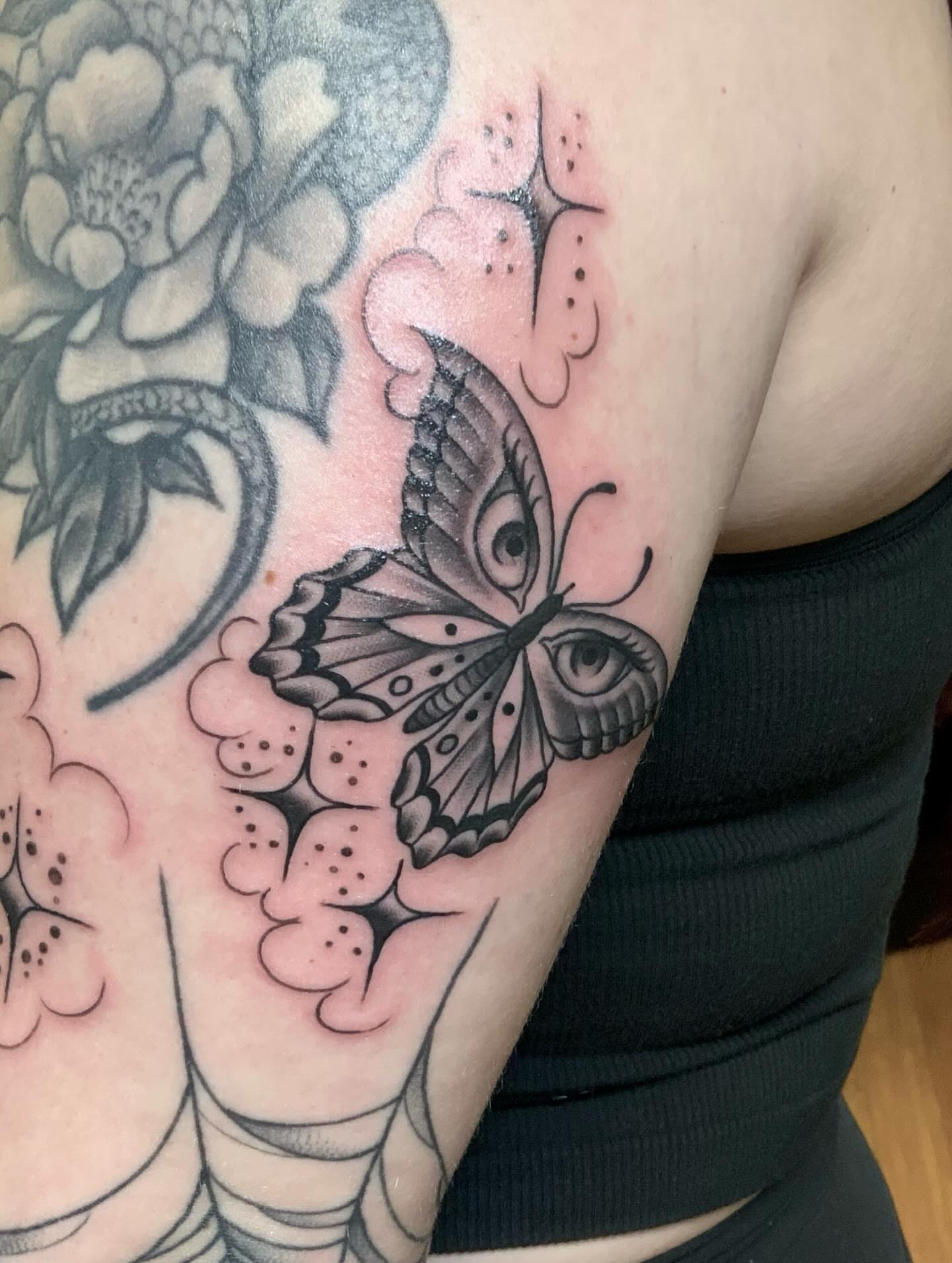 Butterfly and flowers black and grey tattoo on the forearm by Micheal McGlinchey