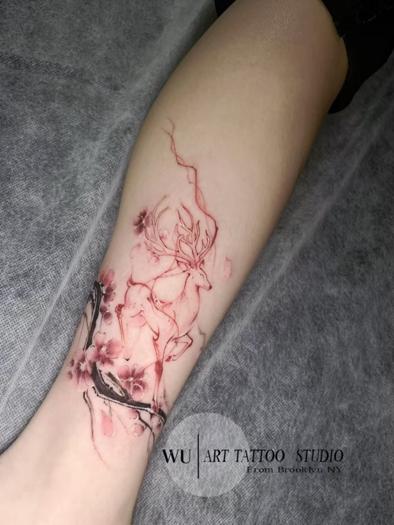 Deer and blossoms watercolor tattoo on the forearm by Ink _daisy_