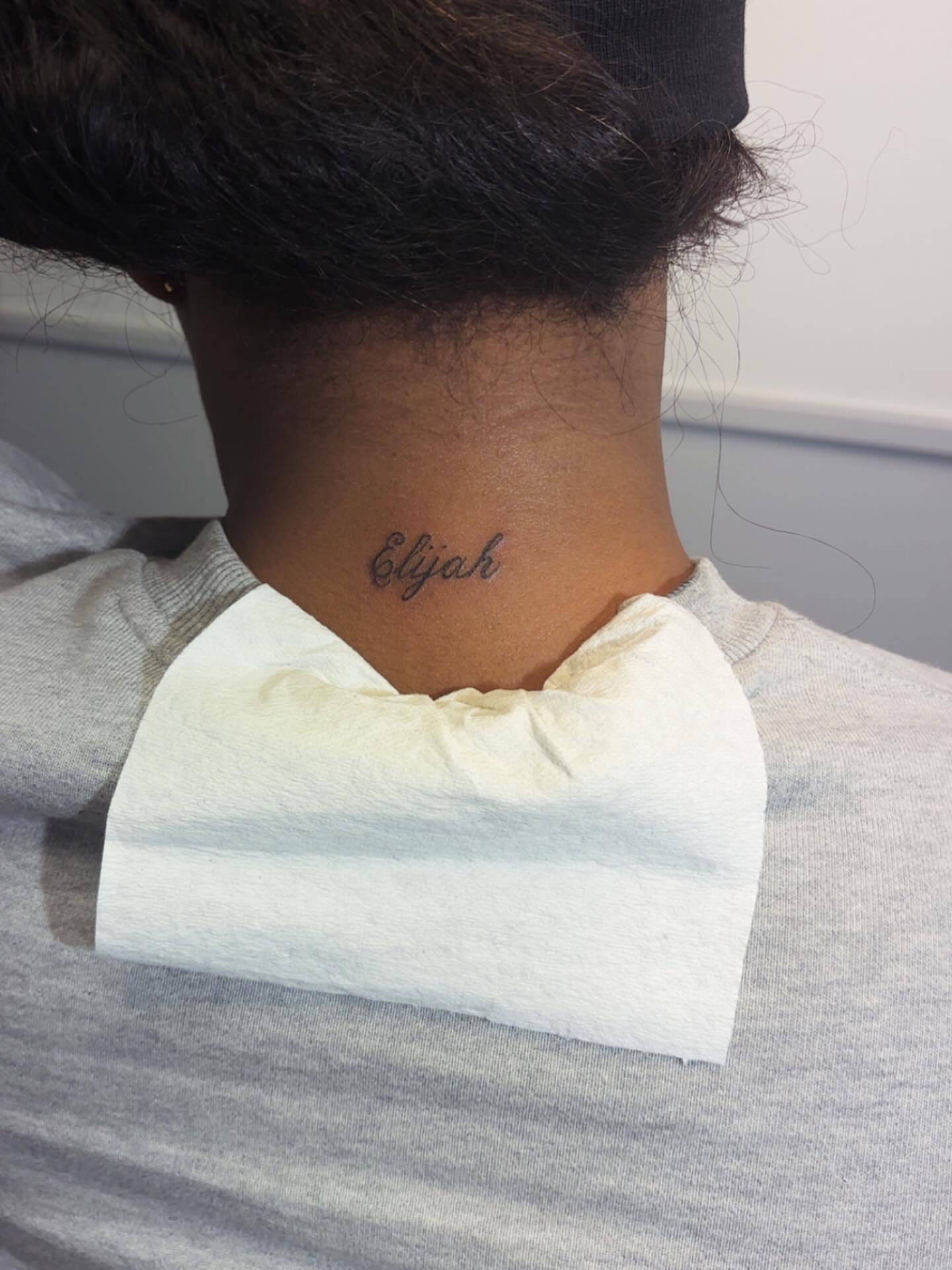 Name lettering script tattoo on the neck by Syneca Wilson, Acton, Massachusetts