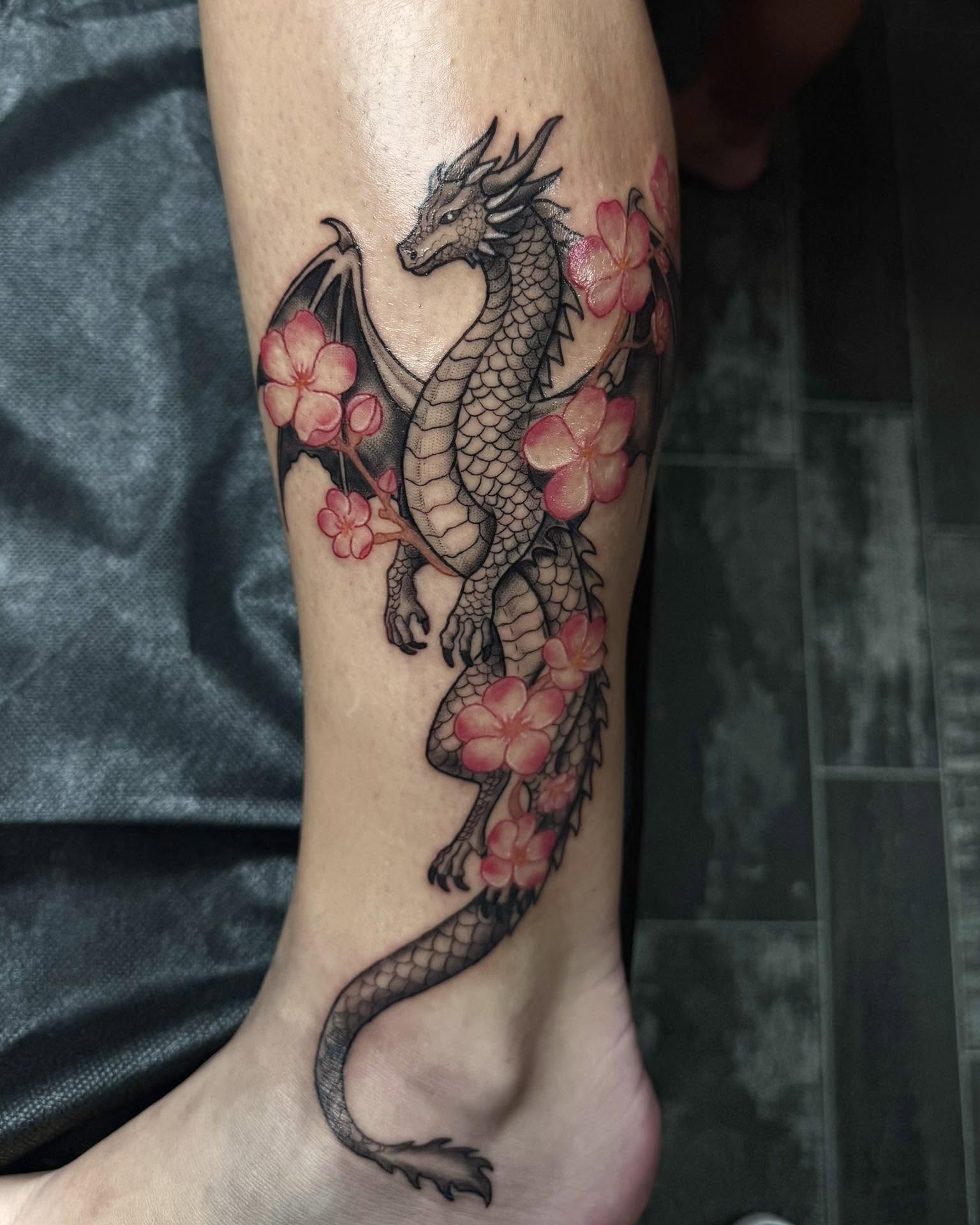 Dragon and flowers realism tattoo on the calf by Madison Jasso