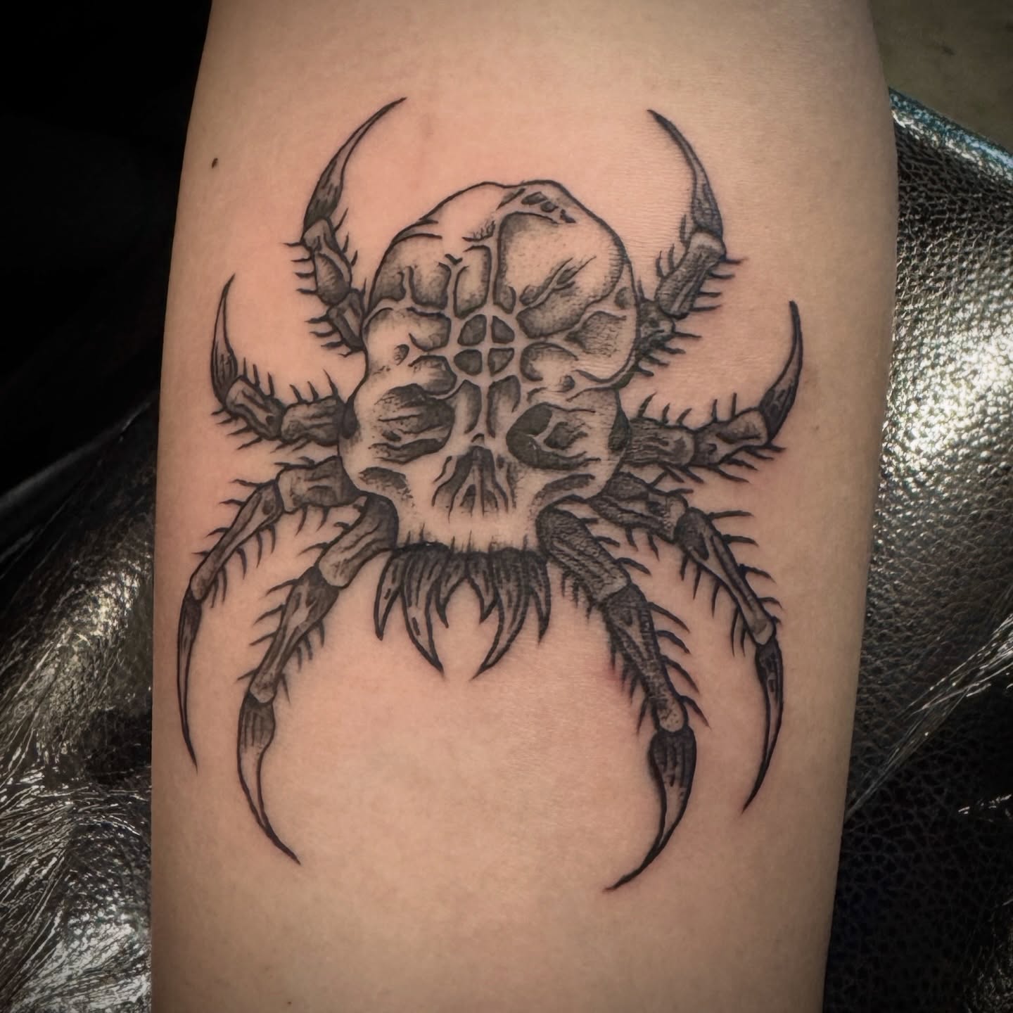 Spider skull geometric tattoo on the forearm by Seth Christianson