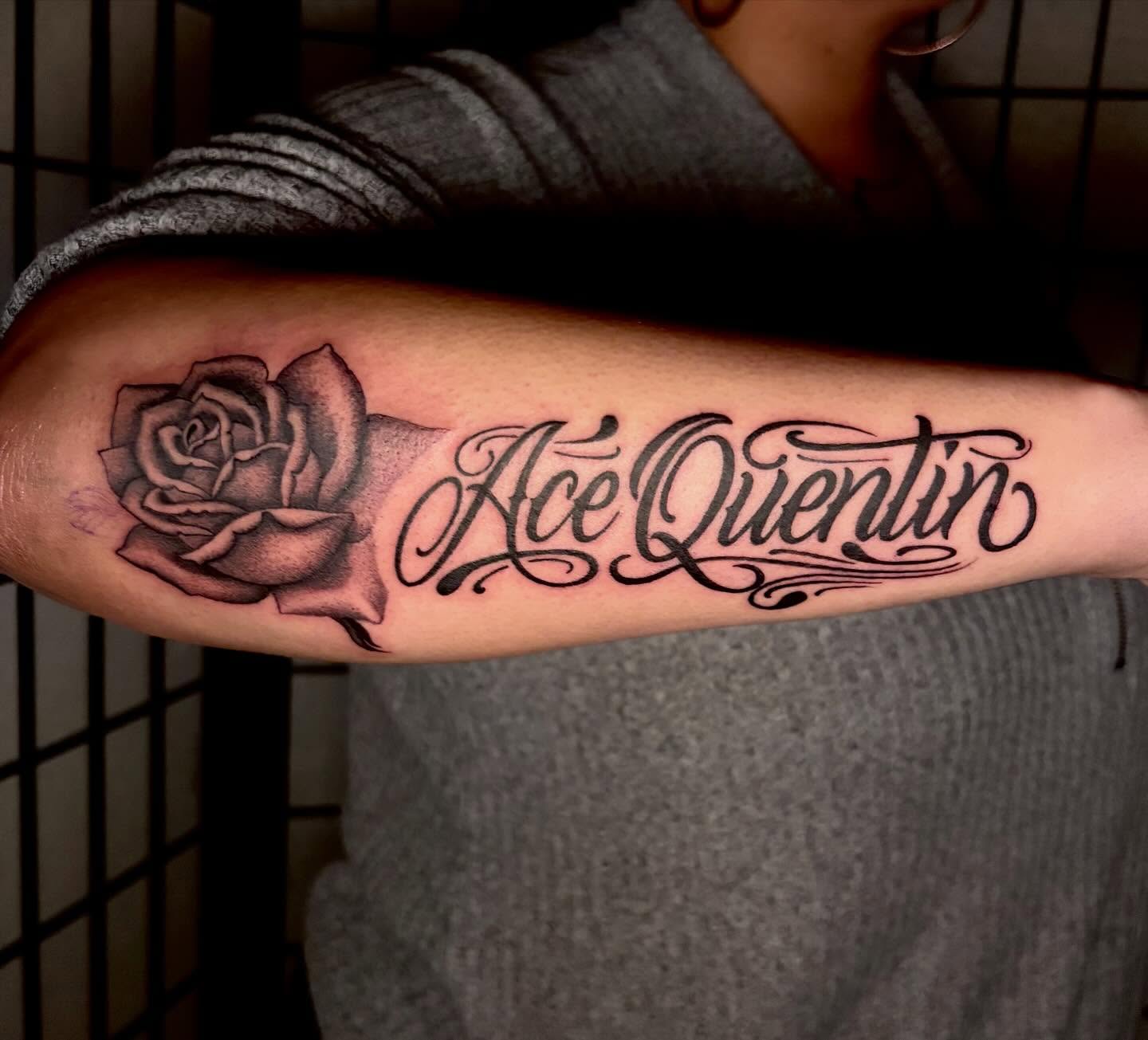 Rose and name black and grey tattoo on the forearm by Tash ๐โ๐ฉ