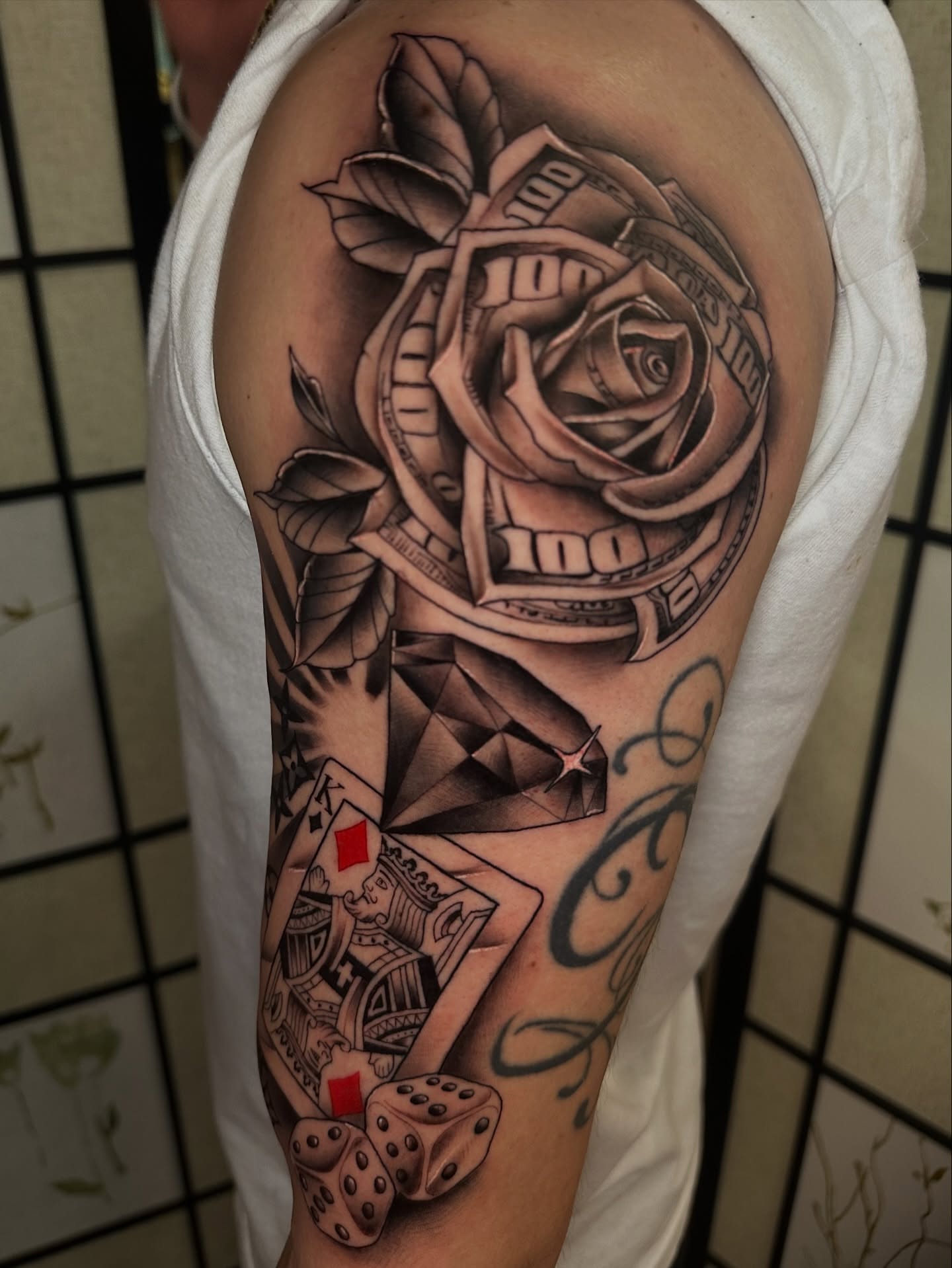 Rose and money realism tattoo on the shoulder by Sam AlpineInk