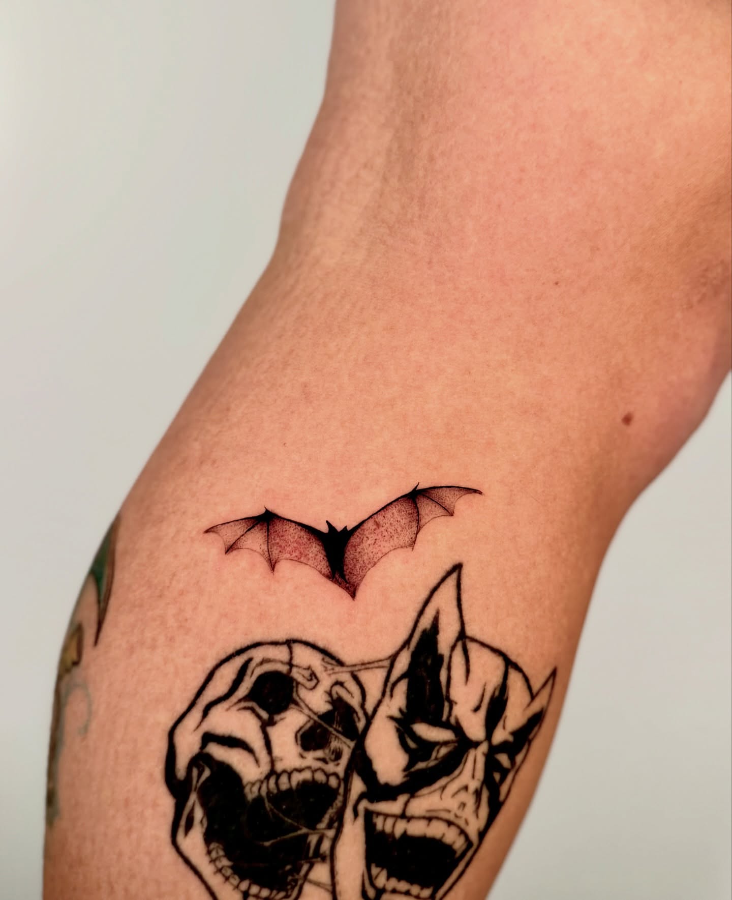 Bat and skulls dotwork tattoo on the forearm by Orca