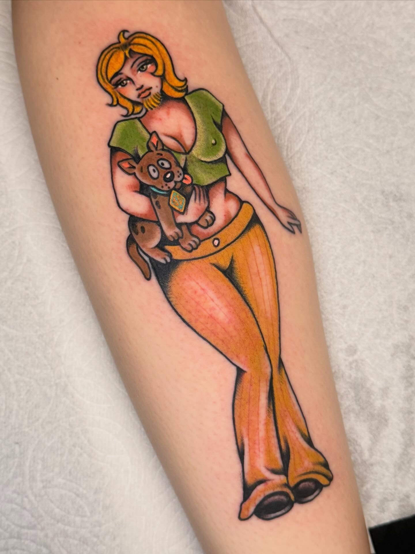 Woman holding dog American traditional tattoo on the forearm by Painted Peach Tattooer