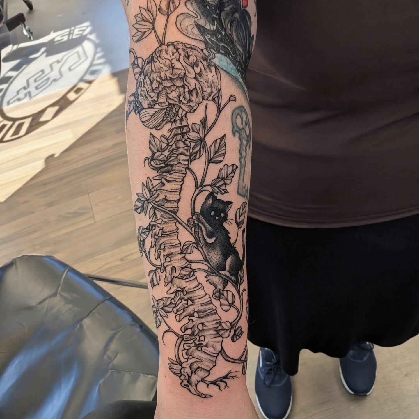 Spine and cat realism tattoo on the forearm by Devon Ward, Portland, Oregon
