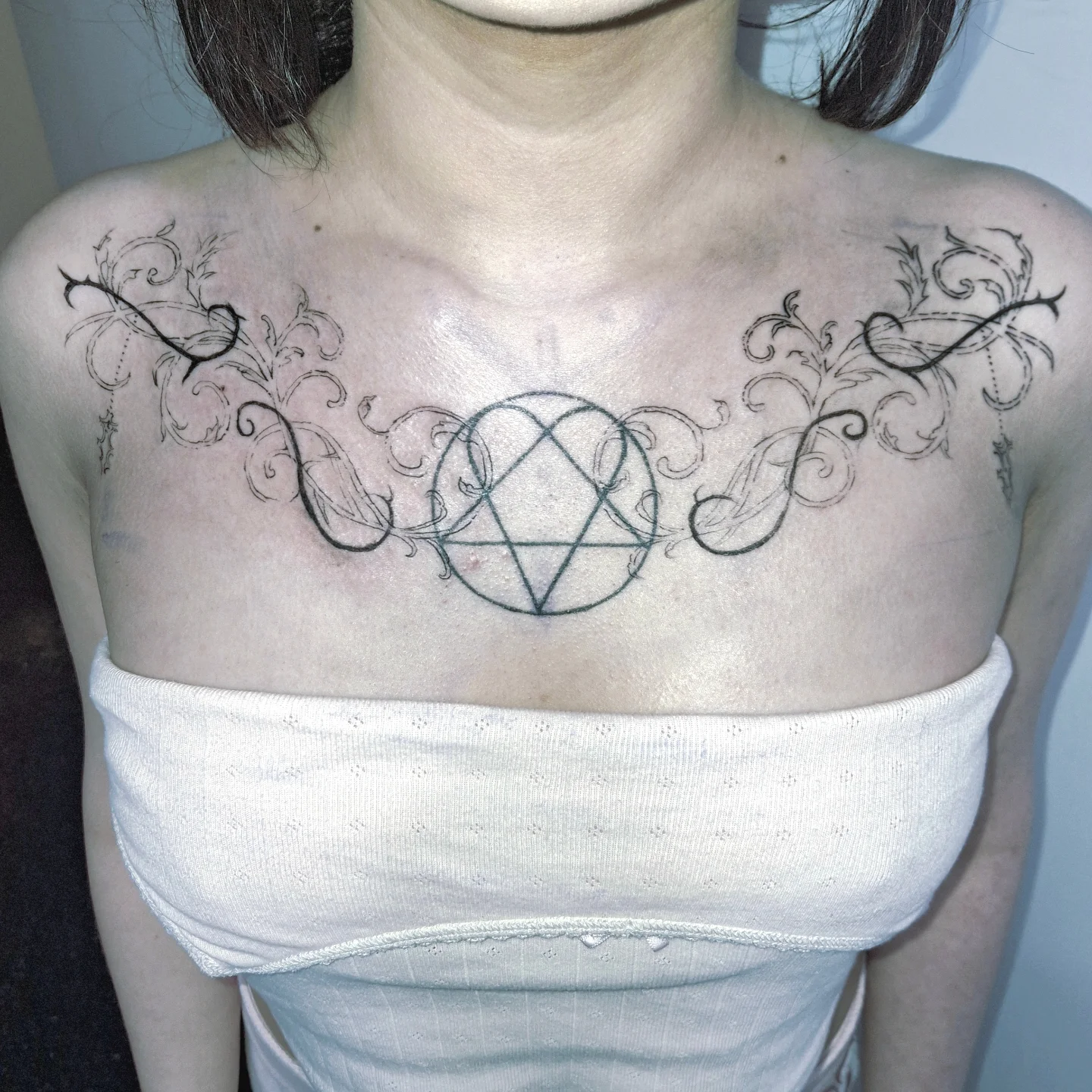 Pentagram with floral ornamentation geometric tattoo on the chest by hallowed girl tattoo