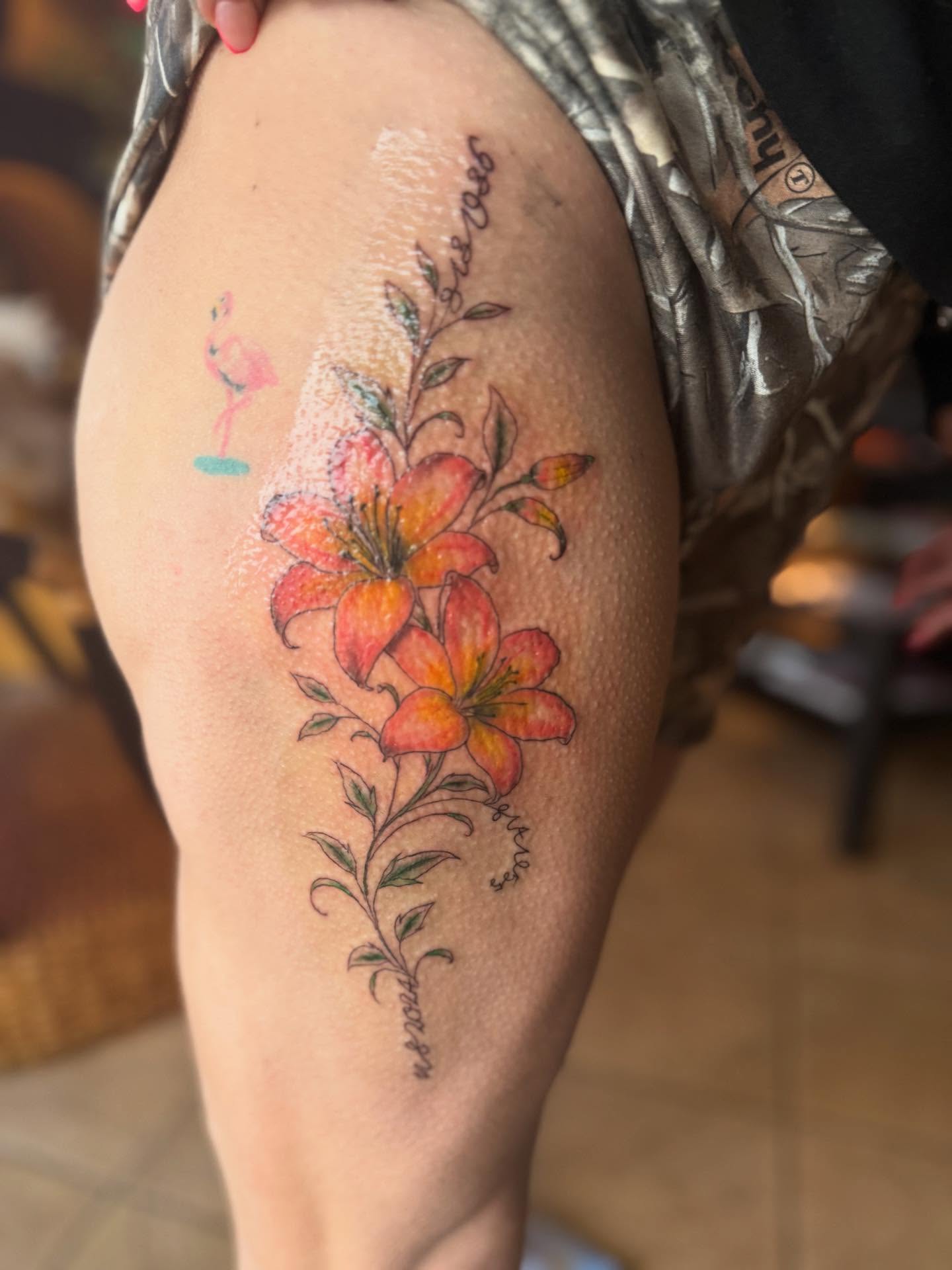 Lilies realism tattoo on the thigh by Tattoos by Santos