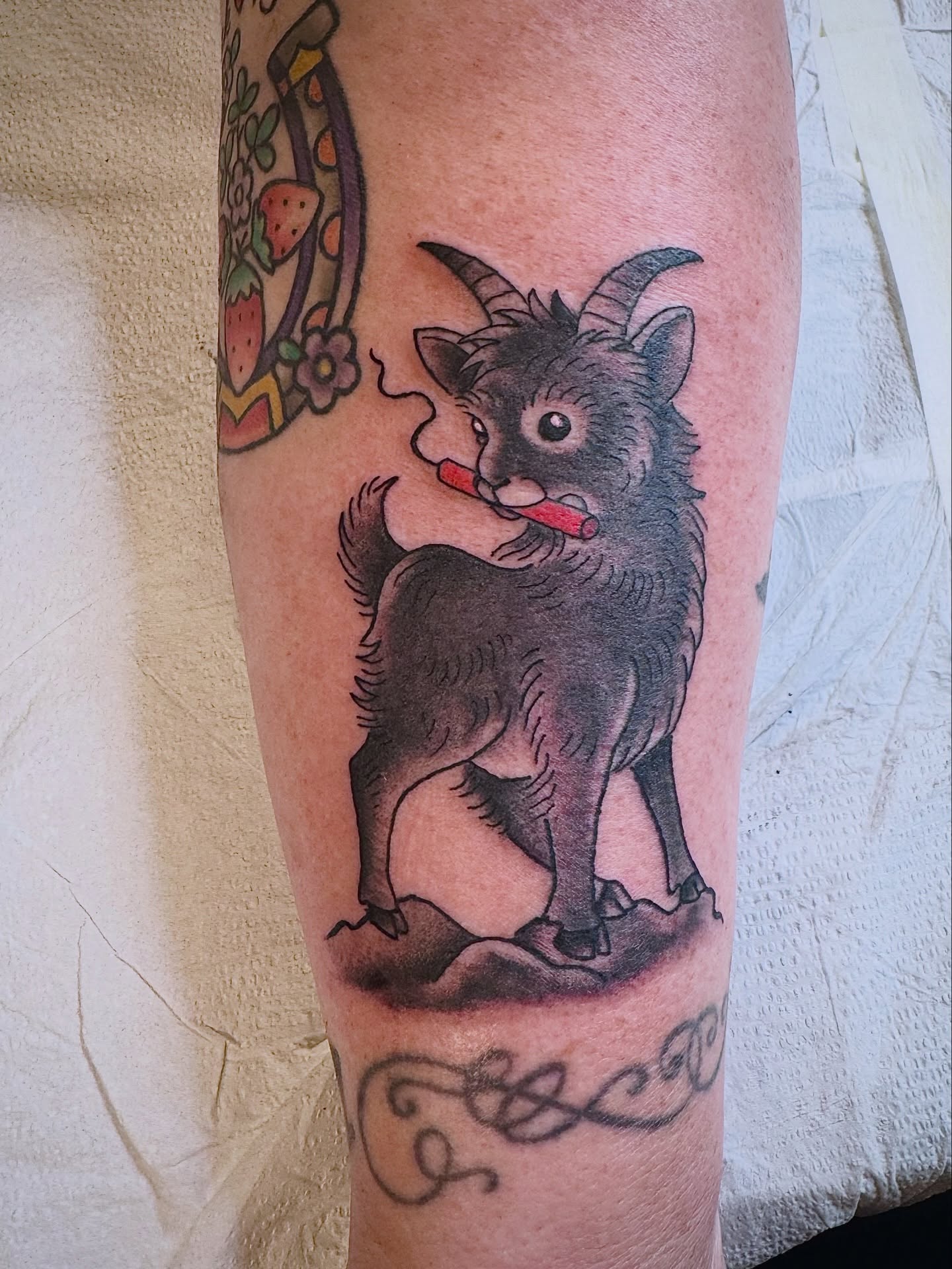 Goat playing recorder black and grey tattoo on the forearm by Aidan Monahan Tattoo