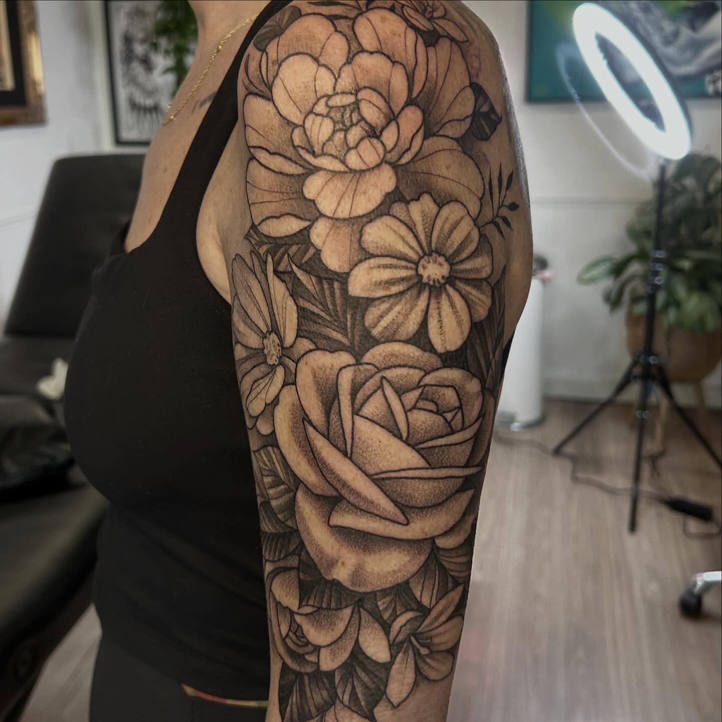 Floral arrangement black and grey tattoo on the upper arm by Whitney Harbin