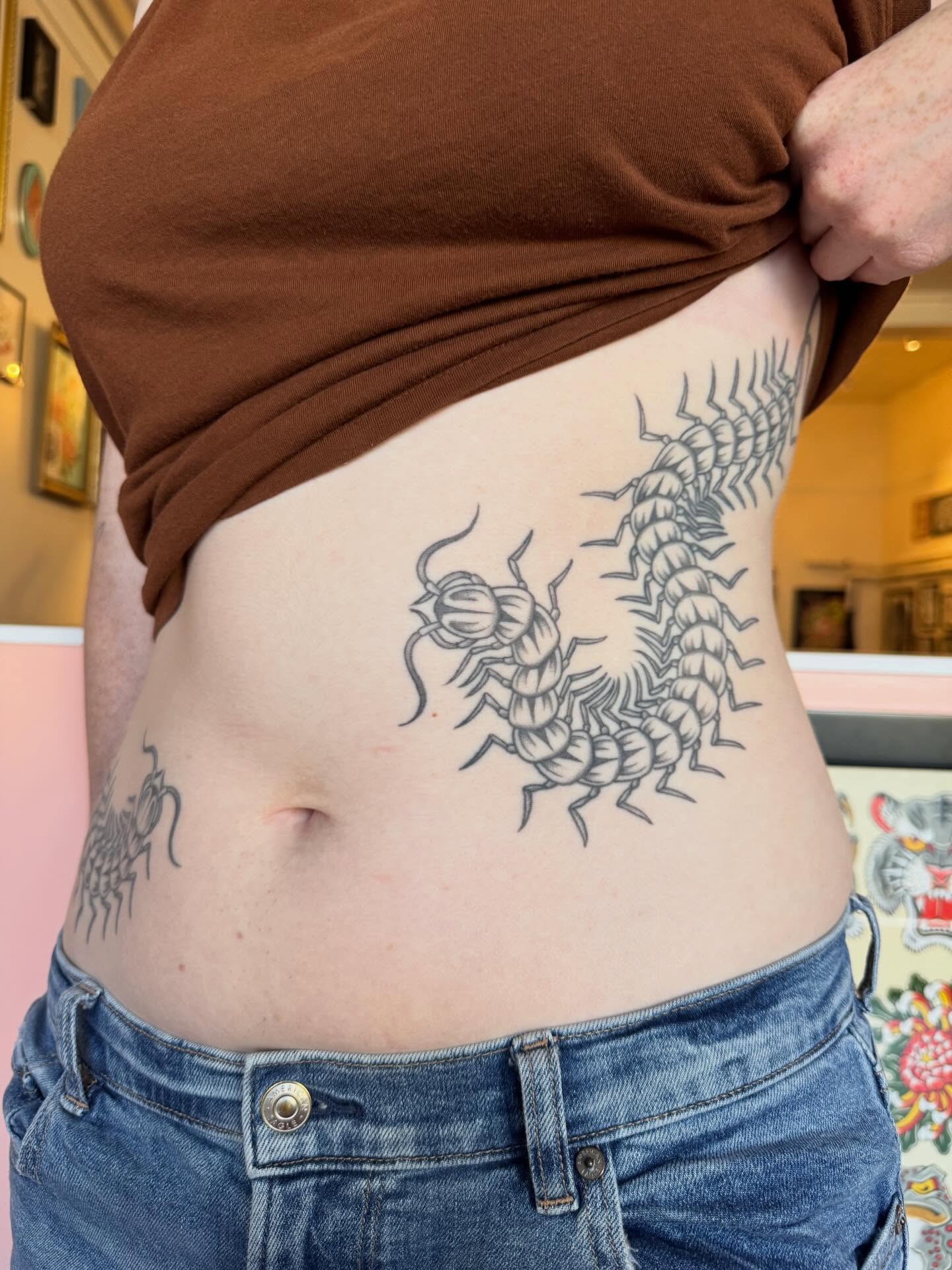 Centipede black and grey tattoo on the torso by Maddie Hammell