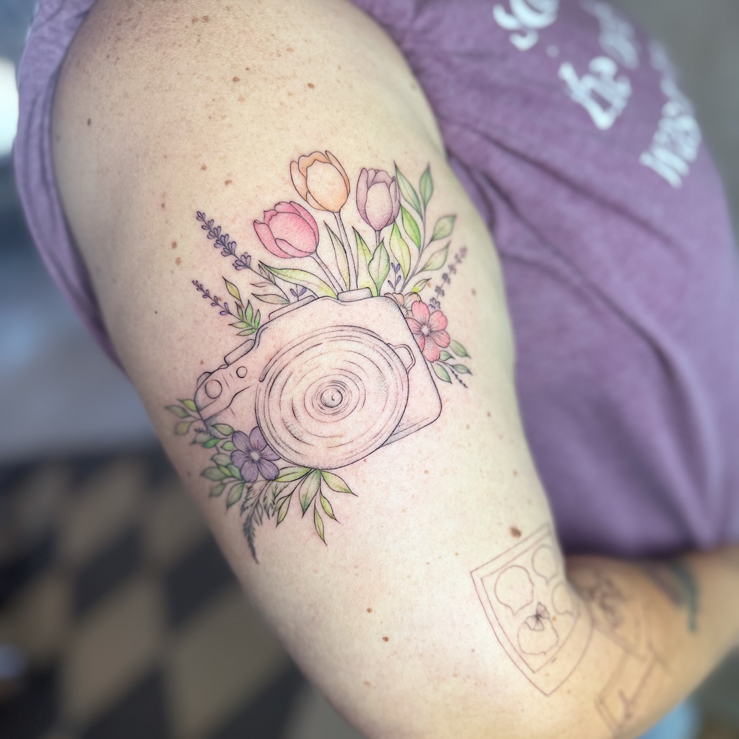 Camera with floral arrangement watercolor tattoo on the shoulder by INK with Christian, Mineral Wells, Texas