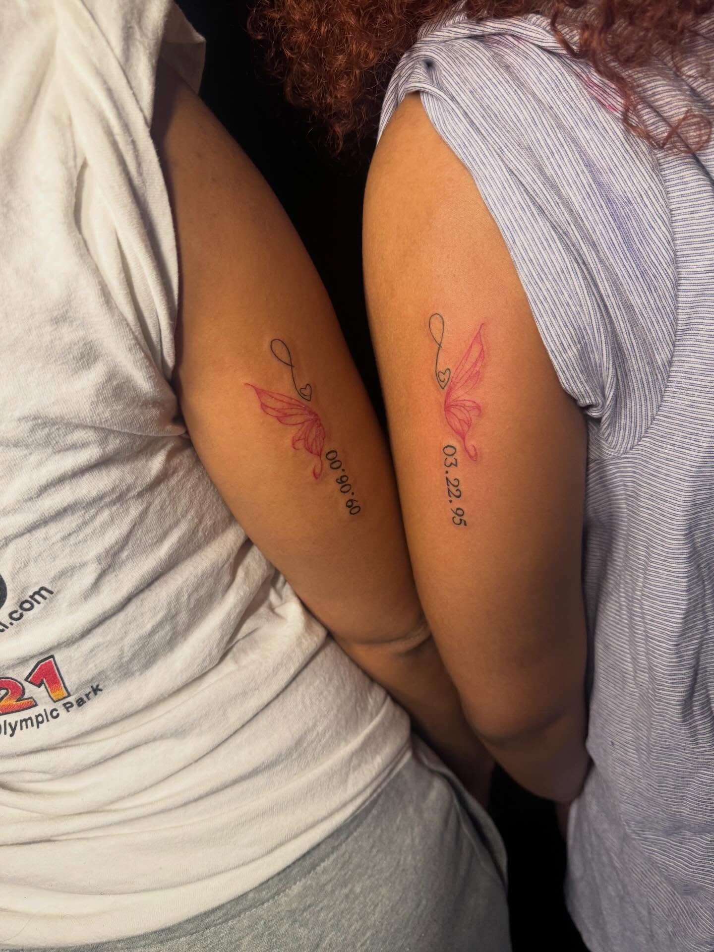 Angel wings and infinity symbol fine line tattoo on the forearm by Kells