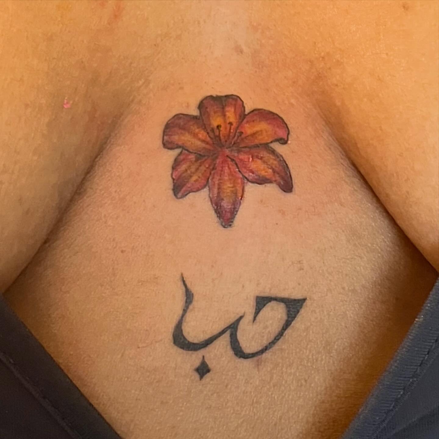 Lily and Arabic calligraphy realism tattoo on the chest by ren