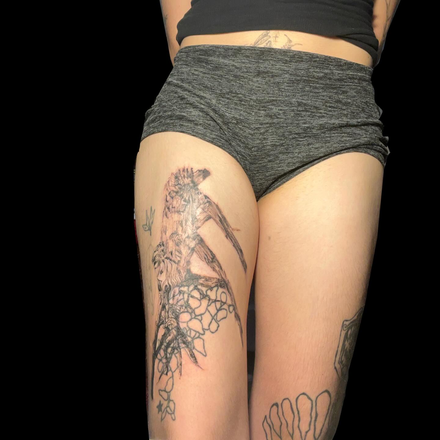 Bird and flowers black and grey tattoo on the thigh by ren