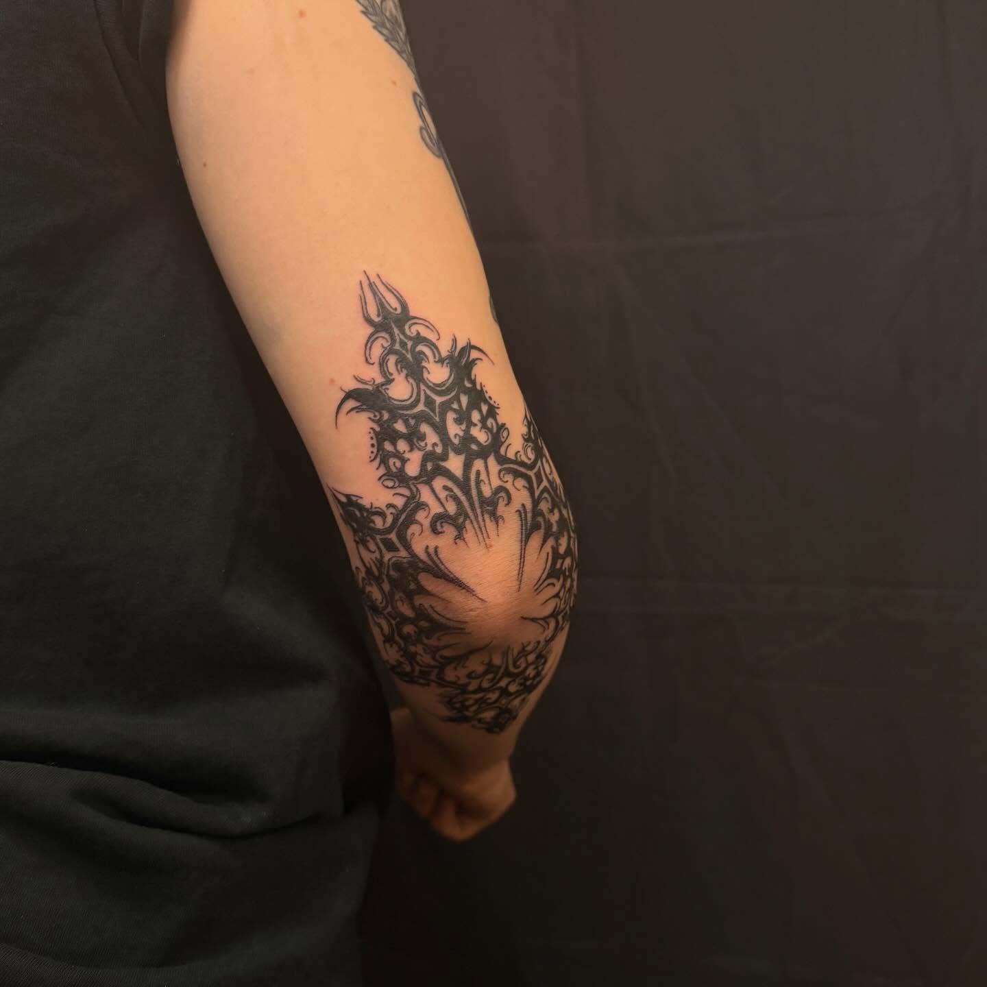 Floral pattern tribal tattoo on the forearm by cortez
