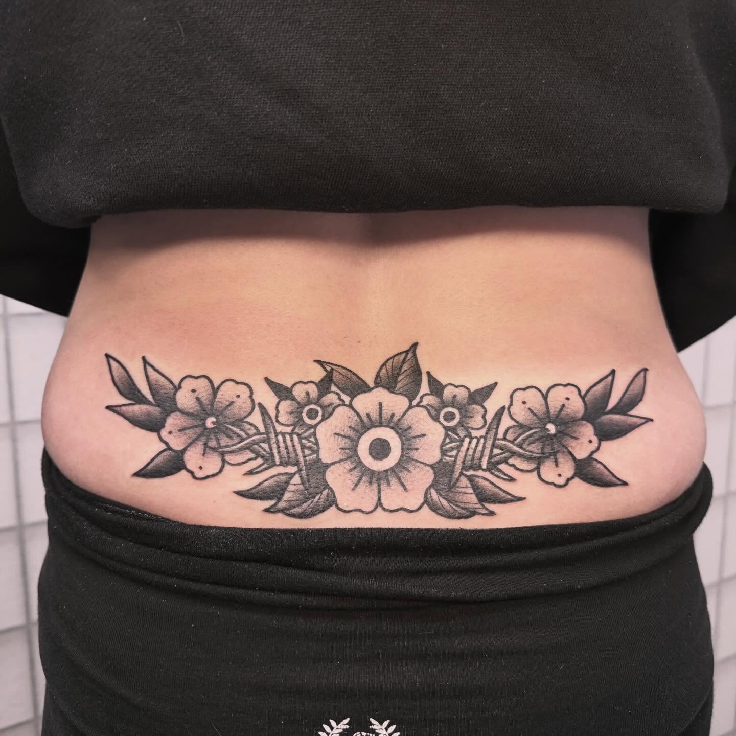 Floral arrangement black and grey tattoo on the torso by Sarah Foltz