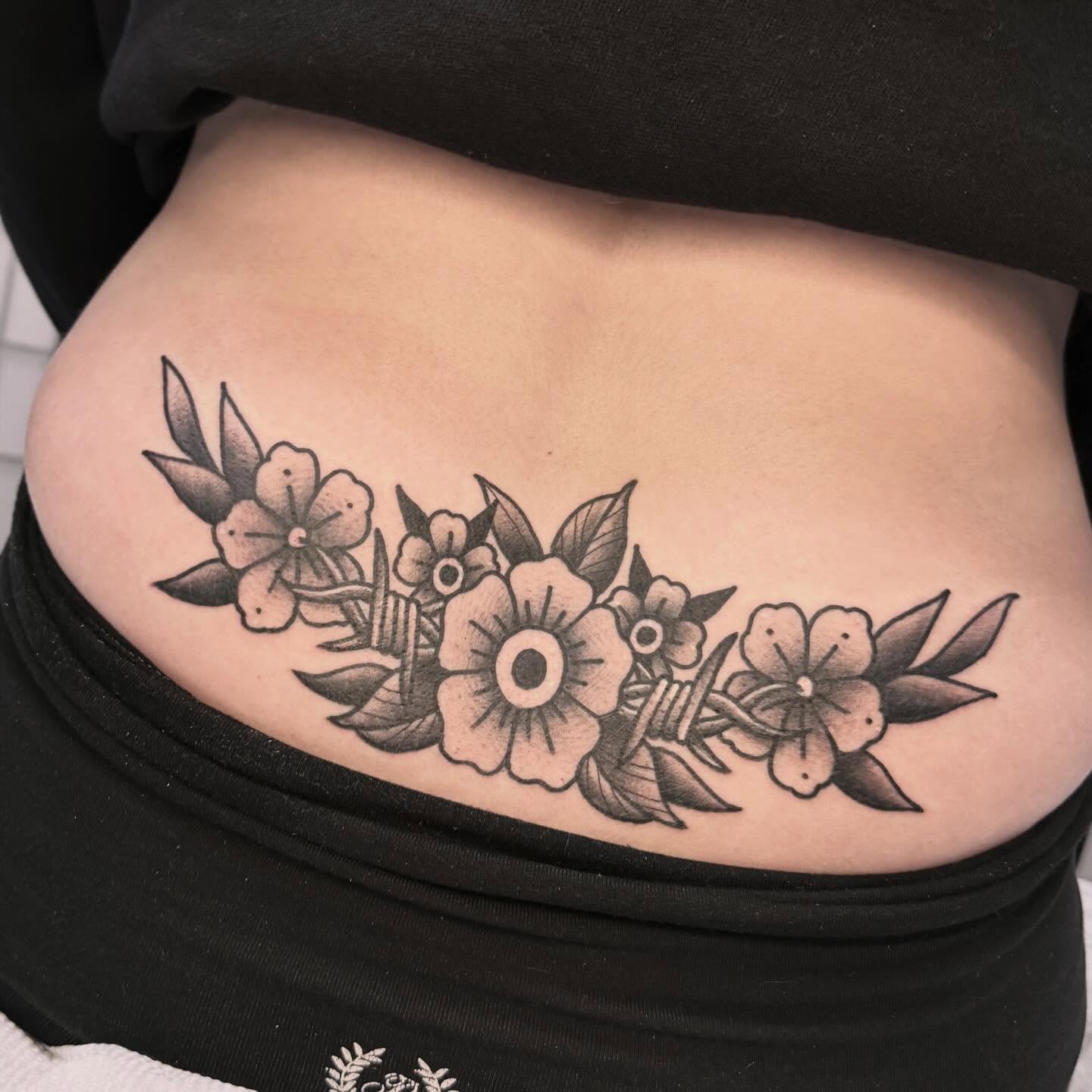 Floral arrangement black and grey tattoo on the ribs by Sarah Foltz