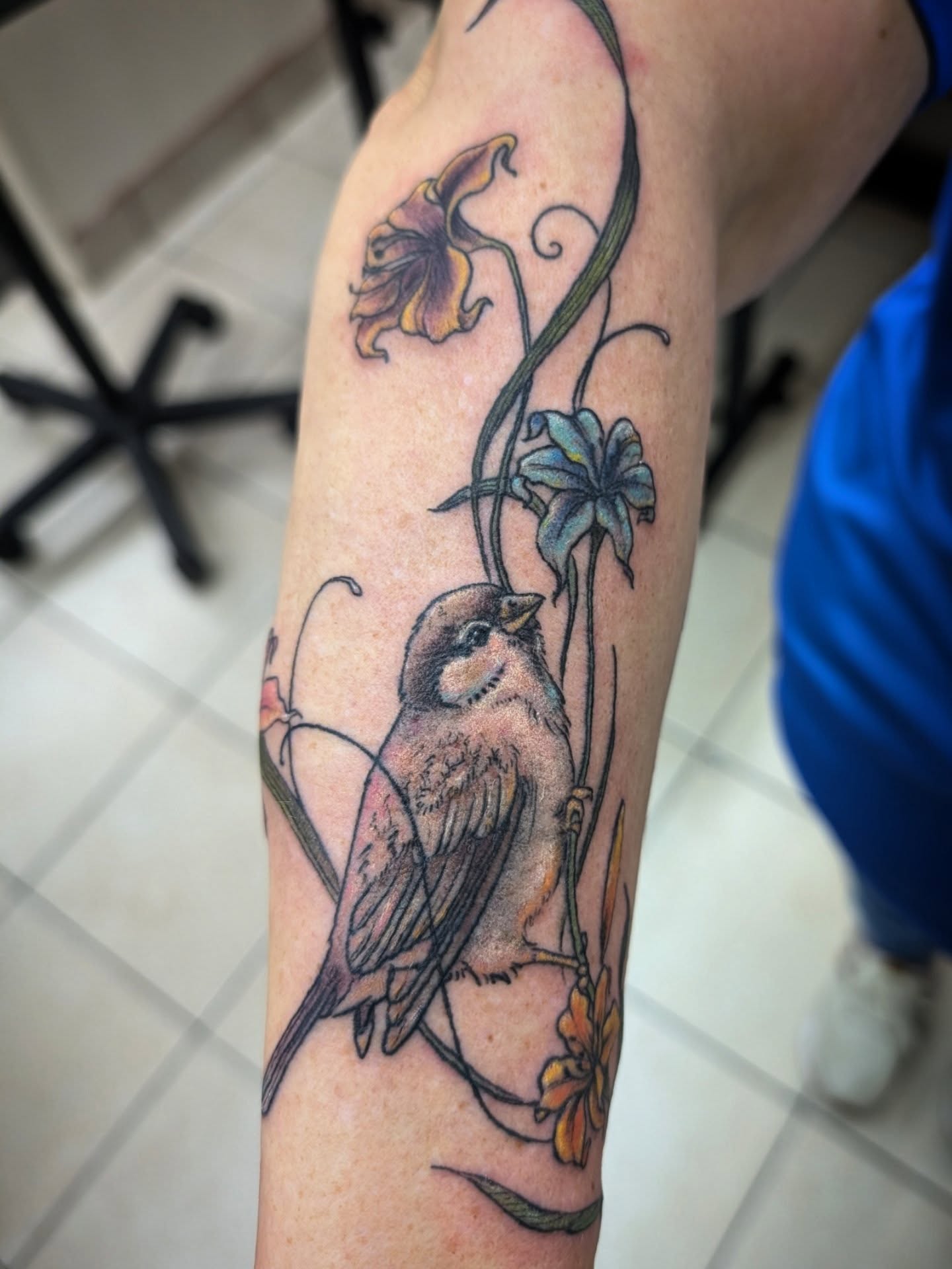 Bird and flowers realism tattoo on the forearm by Katherine