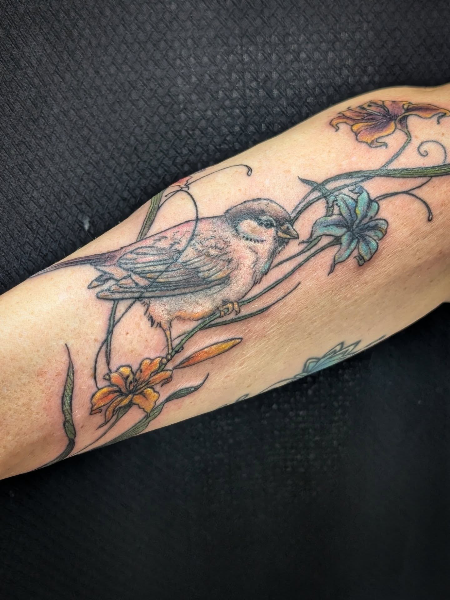 Bird and flowers realism tattoo on the forearm by Katherine