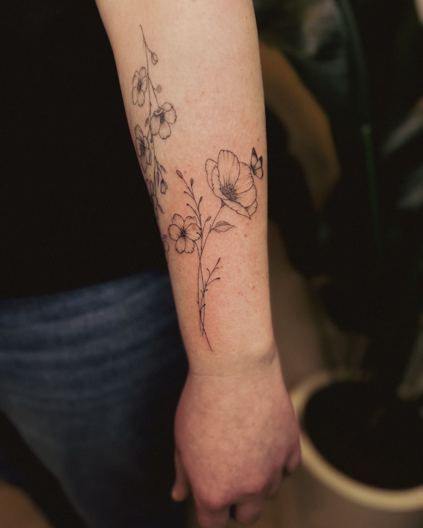Floral design fine line tattoo on the forearm by Ashley Pilgreen