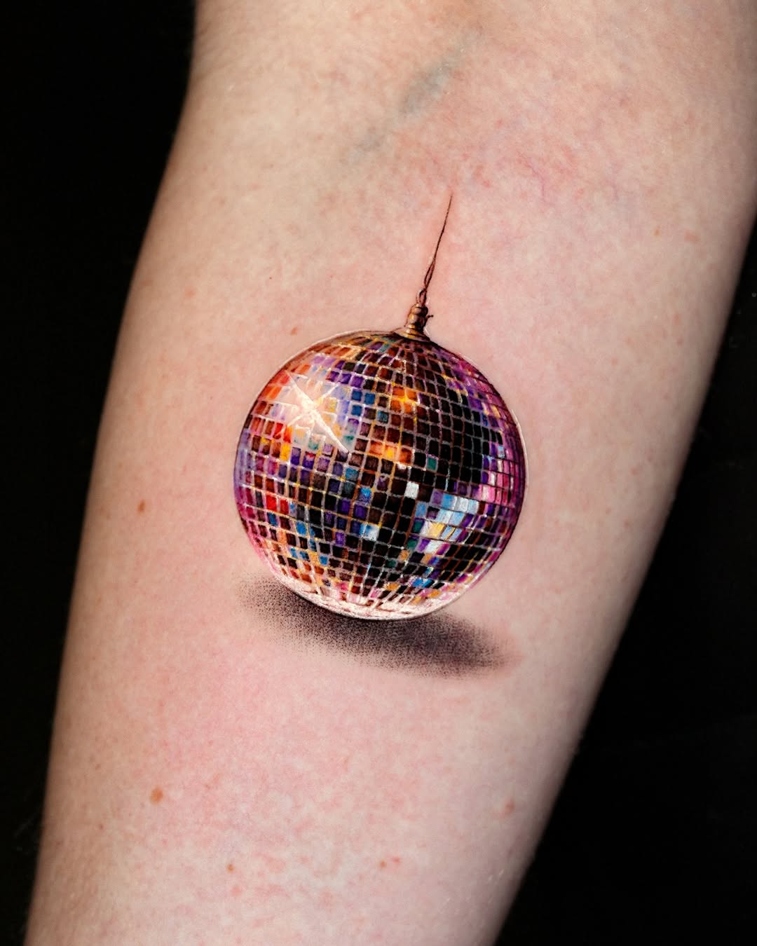 Disco ball watercolor tattoo on the forearm by Gody