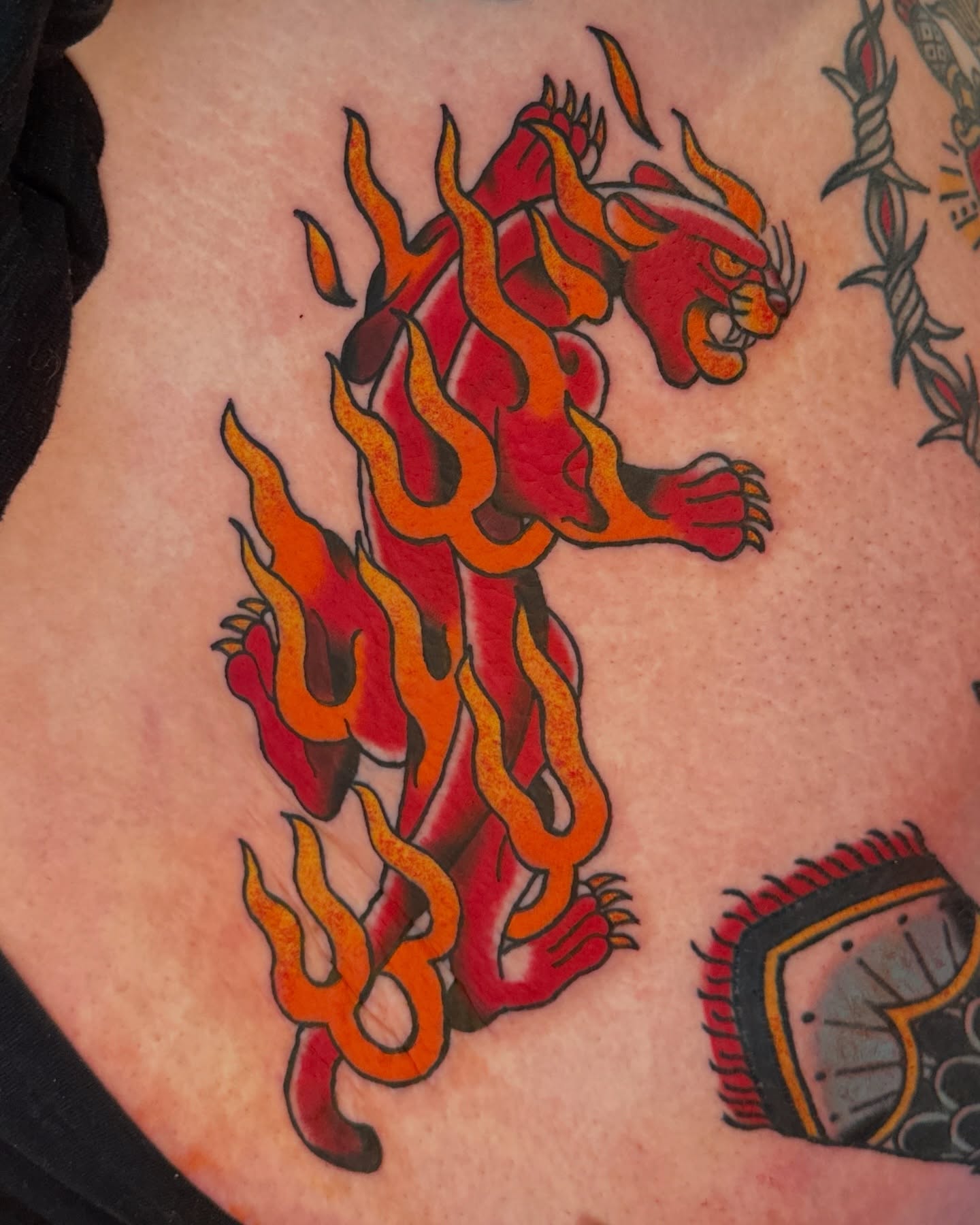 Flaming tiger American traditional tattoo on the torso by Paige Ochoa