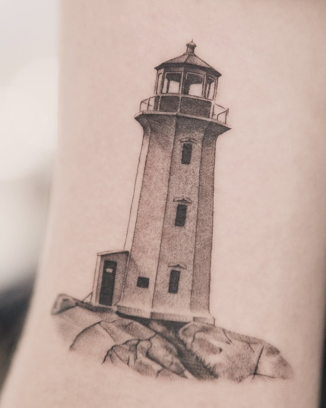 Lighthouse on rocks minimalist tattoo on the forearm by Joey