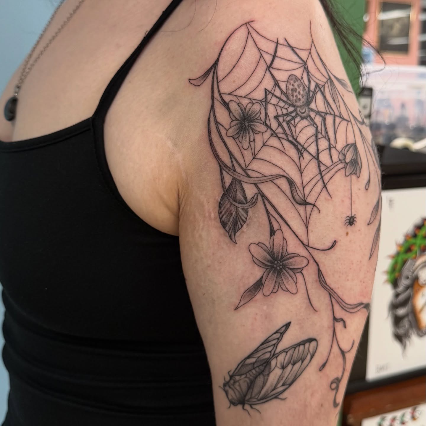 Spider web and flowers realism tattoo on the upper arm by Eva, Matawan, New Jersey