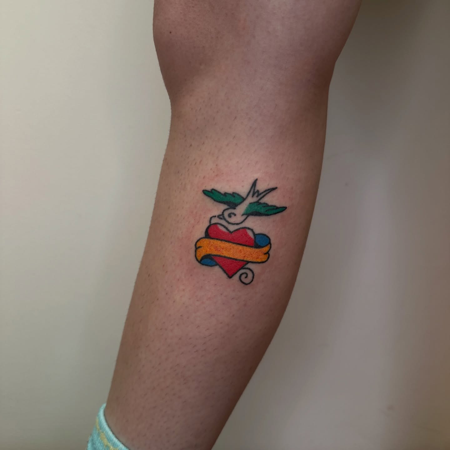 Heart with dove American traditional tattoo on the forearm by paulina