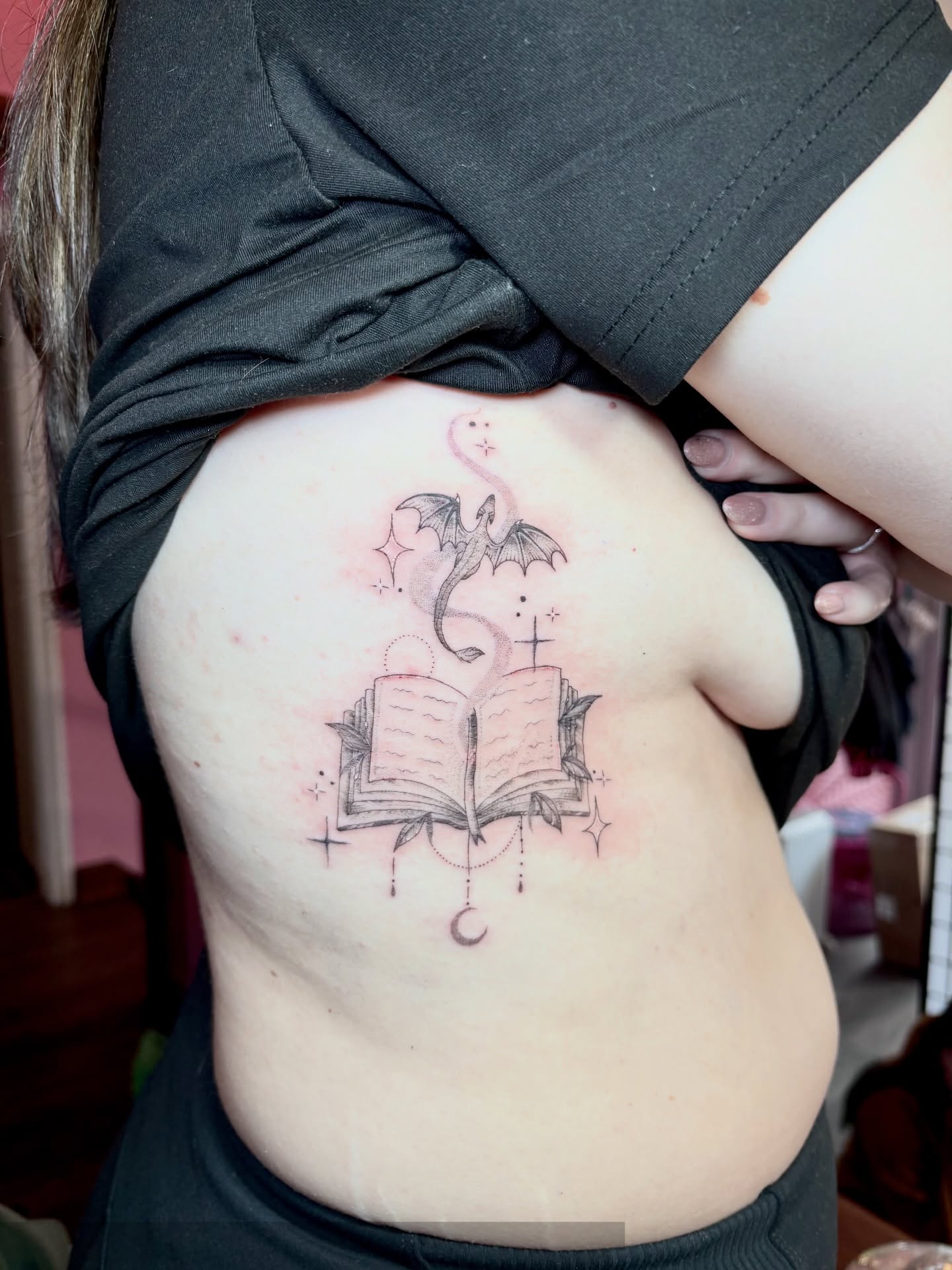 Book with dragon black and grey tattoo on the ribs by Charlotte Brown, Leeds, England