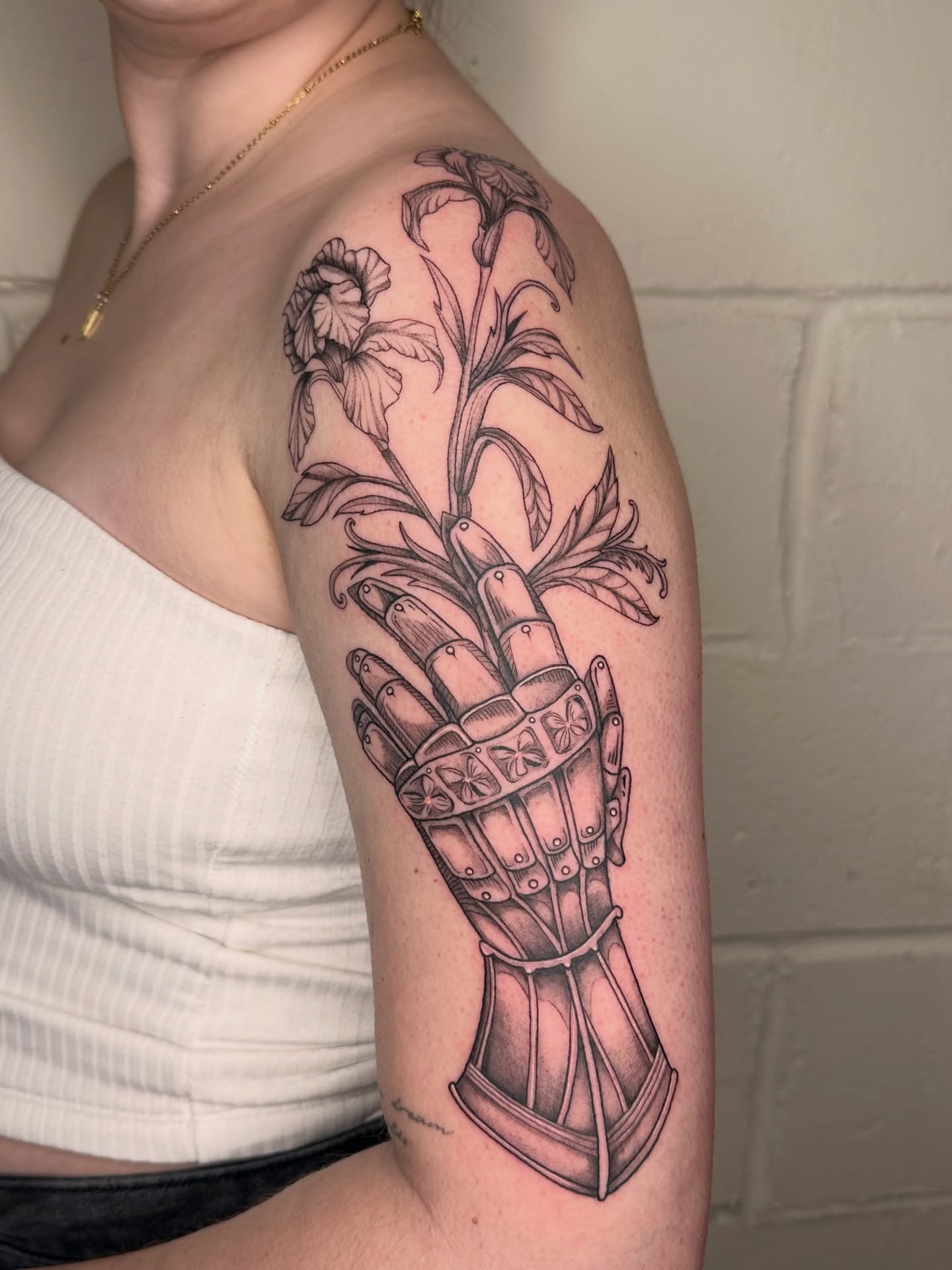 Glove and flowers black and grey tattoo on the forearm by father