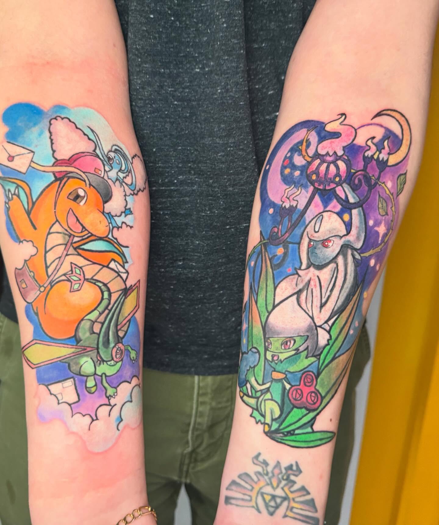 Charizard and omanyte watercolor tattoo on the forearm by Paula.p.tattoos