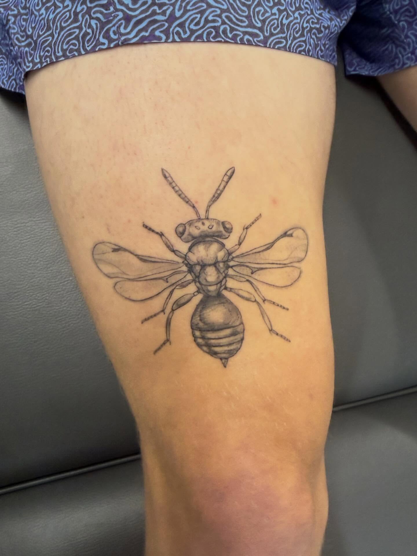 Bee black and grey tattoo on the thigh by Peter Harren
